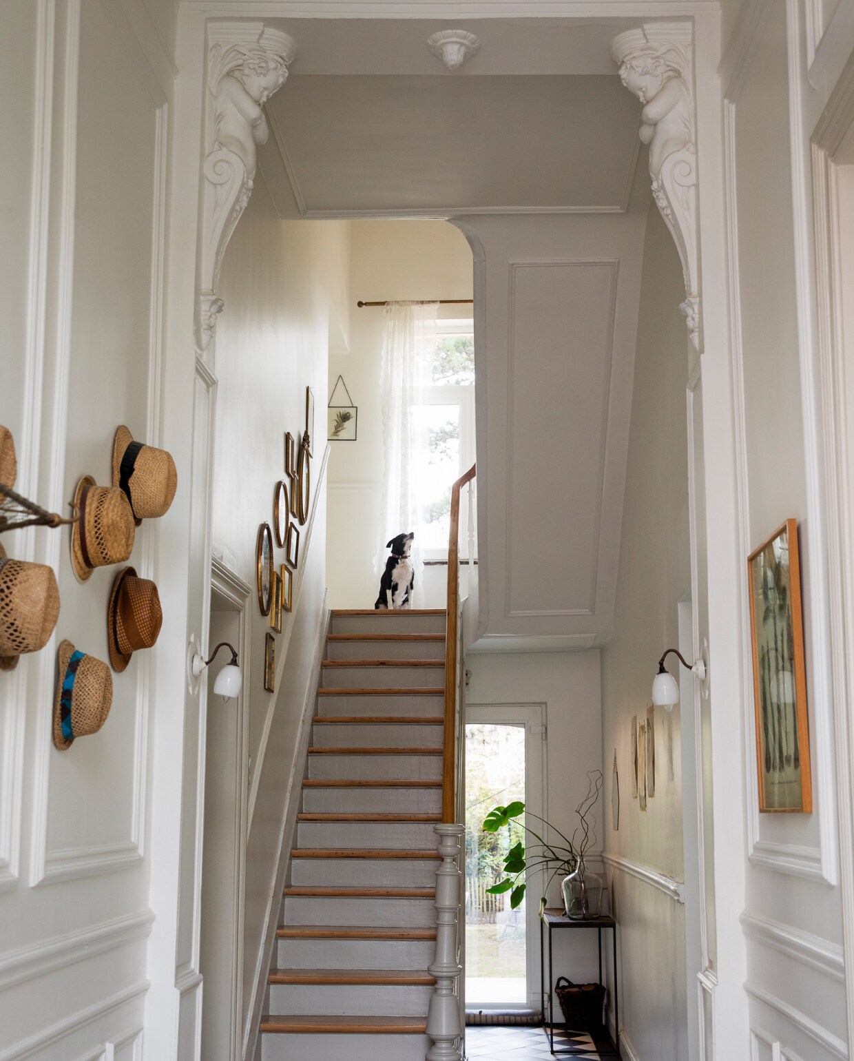 Verf trap Hardwick White van Farrow &amp; Ball. Muurverf Ral 9010. Vloer Villeroy &amp; Boch, lijsten Wunderkammer, wandlampen ’t Glashuys, bijzettafel Juntoo, mand brocante. Overig onbekend. 2 Muurverf Ral 9010, schilderij kringloopwinkel. Koffers en doos brocante, stoel markt Marollen, kussen Zeeman, tafel op maat gemaakt, bureaustoel Bol. vtwonen 10-2023 | styling Ilona Jongepier | fotografie Dana van Leeuwen