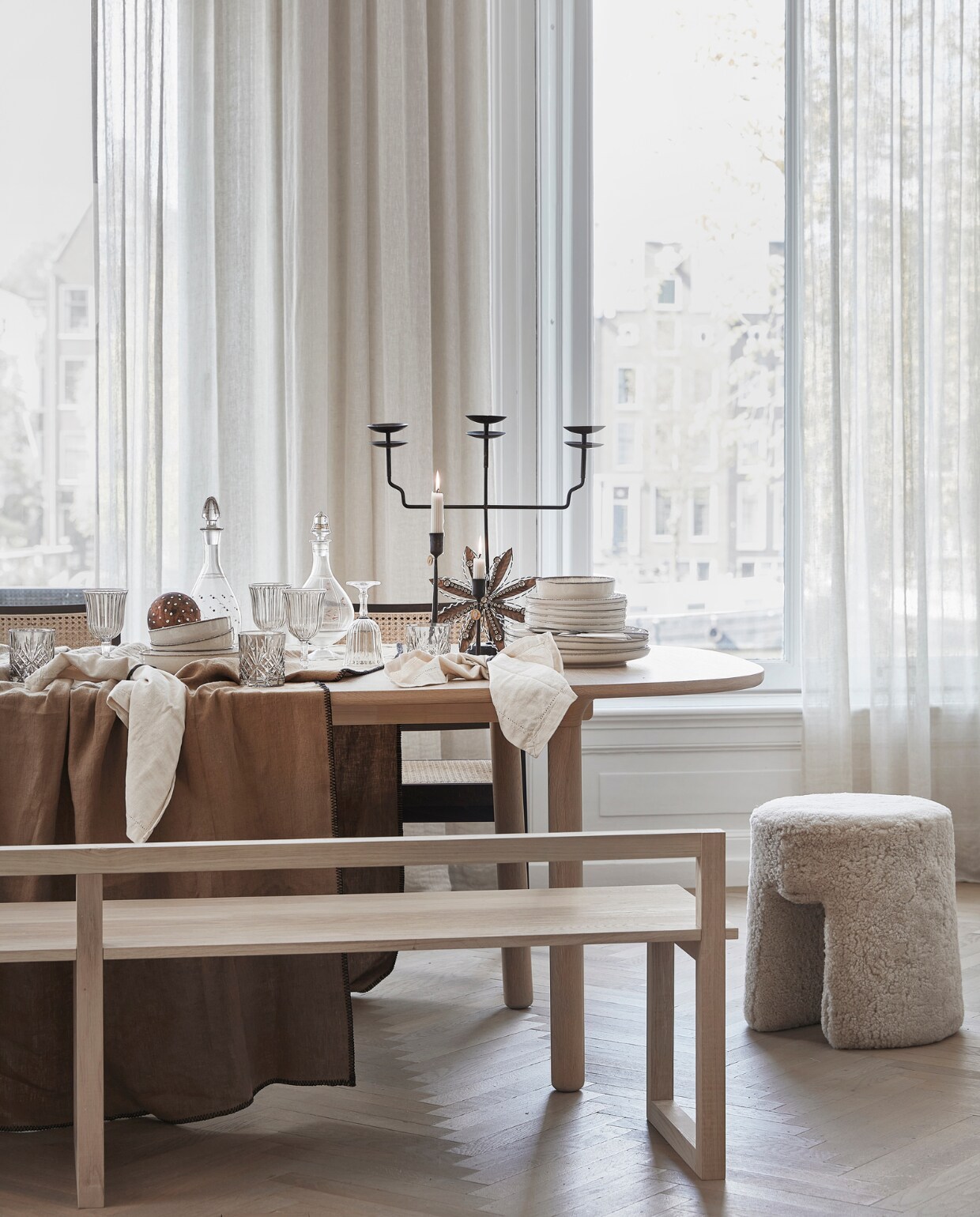 Lamswollen poef Sequioa van Frederica, 40 cm (Ø) € 1269,- (designtales.nl). Donkerbruine rotan eetkamerstoelen Pierre met armleuning, per stuk € 399,- (aimetestudio.com). Linnen tafelkleed Lola kleur Tabac, 170x300 cm € 132,95 (casagitane.com). Wijnglazen, per stuk € 3,99, drinkglazen, per stuk € 7,99, beige servies vanaf € 6,99, servetten, per 2 € 9,99 (zarahome.com). Dinerkaarsen ribbel, per stuk € 2,35 (bluryourlife.com). Zwarte lantaarn van Taiwan Lantern € 1150,- (entertheloft.com). Zwarte, drie-armige kandelaar € 57,95, zwarte kandelaar M € 18,25 L € 19,25, sneeuwvlokhanger € 15,50, handgemaakte koperkleurige kerstbol met stippen € 6,95 (weldaad.com). Witte papier-maché schaal Earth van Serax € 179,-, zwarte messing servetringen van Ferm Living, per 5 € 32,99 (vtwonen.be). Oude glazen karaffen (kringloopwinkel). Gordijnen privébezit. vtwonen 12-2022 | stling Kim van Rossenberg | uitvoering Richard van Meerveld | fotografie Peggy Janssen