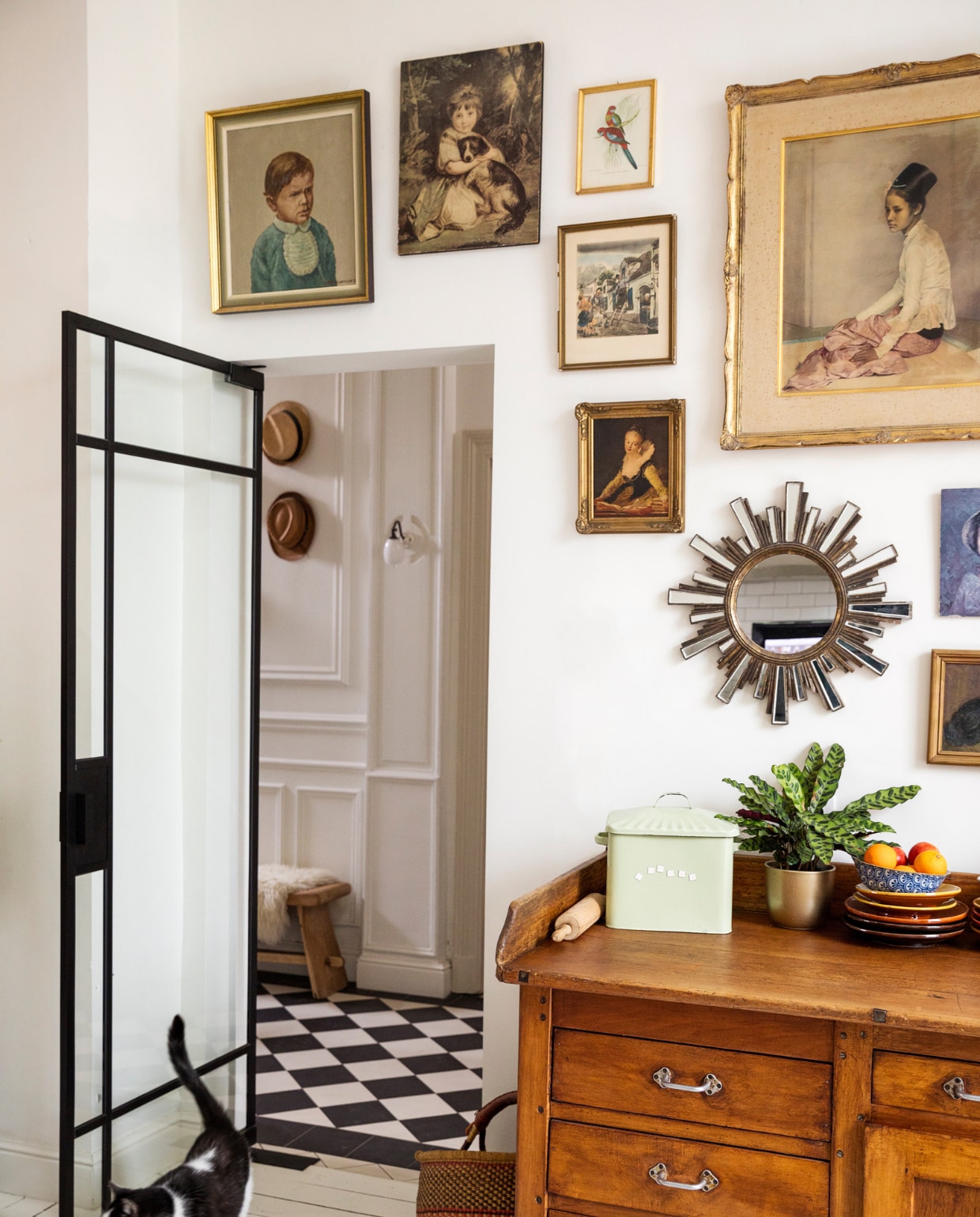 Verf muur en vloer Ral 9010, vloertegels hal Villeroy &amp; Boch. Bank Polspotten, schapenvacht Ikea, wandlamp ’t Glashuys. Lijsten kringloopwinkels en rommelmarkten, spiegel brocante, keukenblok/oud bakkersmeubel Woontheater. Mand markt, blik souvenir, plant en pot Van Uytsel, servies Marokkaanse winkel. Overig onbekend. vtwonen 10-2023 | styling Ilona Jongepier | fotografie Dana van Leeuwen