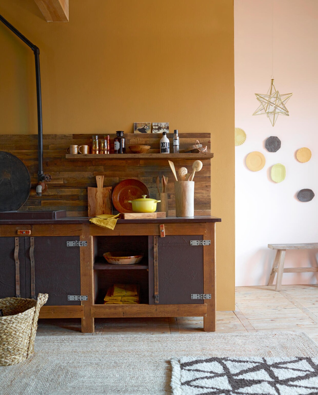 De muur achter het keukenblok is geschilderd in kleur Cottage, muurverf per liter € 20,50, op de muur rechts kleur Honeymoon muurverf per liter € 20,50 (Dimago). Keuken met een houten achterwand, spoelbak en kastdeuren van canvas en leer, vanaf € 850,- (Combitex). Houten potten per stuk vanaf € 23,50, glaswerk € 3,95, pollepels per set vanaf € 6,95, okergele schaal € 35,-, houten schijven met leren riempjes € 15,95, sterlamp € 115,- (Household Hardware). Houten snijplanken per stuk € 49,95, mokken per stuk € 6,95 (Storebror). Apothekersfles vanaf € 17,50, mand € 49,95 (Nordal). Gele pan van Le Creuset € 179,-, houten schaaltje € 15,50, olie € 18,95, zout € 9,95 (Nijhof). Jute vloerkleed 160x230 cm € 325,- (Coco-mat). Vloerkleed van wol, met de hand geknoopt € 1253,35 (Friday Next). Linnen servetten per stuk vanaf € 3,95 (Sissy-Boy). Houten bankje van oud teakhout lengte 75 cm € 159,- (Hoffz). Bordjes aan de muur per stuk vanaf € 65,- (Little Owl Design). Ansichtkaart vanaf € 1,10 (Art Unlimited). vtwonen 01-2016 | styling Marianne Luning | fotografie Tjitske van Leeuwen