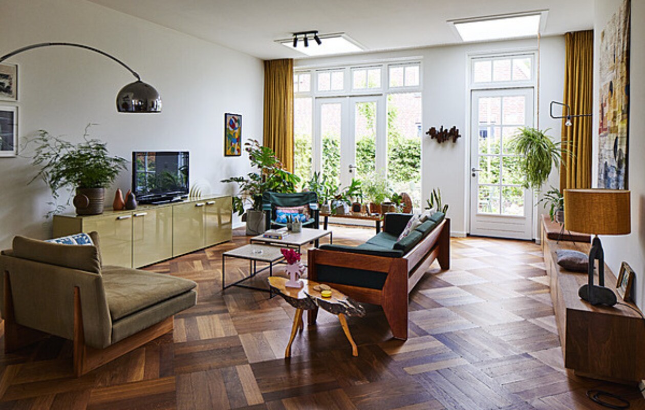 Loveseat Sofa, muurlamp, schemerlamp, wandkleed en muurbank X+L. Groene bank, peren, bijzettafel boom, klein schilderij vintage. Kussens zelfgemaakt, palmboomvaas Stüssy, salontafels Schriever Interieurbouw, dressoir Cappellini, vintage plantenpot Mobach Keramiek, witte lamp Raak, vilten kunstwerk Marktplaats, groene fauteuil Hay, kussen A.p.c., houten bank Nelson Platform Bench. Diverse potten Wildernis, vintage en Serax. Wandsculptuur Ming Stylemeister, spotjes Sofisticato van Koen Van Guijze van Serax. Overig onbekend. vtwonen 11-2023 | styling Mariella Kallenberg | fotografie René Mesman