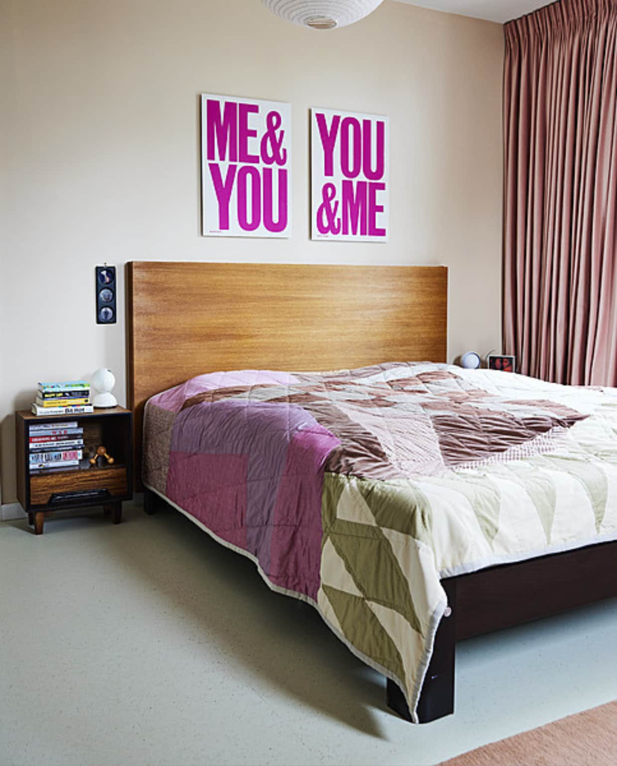 Bed Auping, houten hoofdbord op maat gemaakt, bedlampen Eclisse van Artemide, quilt A.p.c., nachtkastje vintage, gordijnen Links &amp; Co, vloer Marmoleum Cocoa van Forbo. Hanglamp en vloerkleed Hay. Ingelijste foto Ewoudt Boonstra, posters Anthony Burrill. Overig onbekend. vtwonen 11-2023 | styling Mariella Kallenberg | fotografie René Mesman
