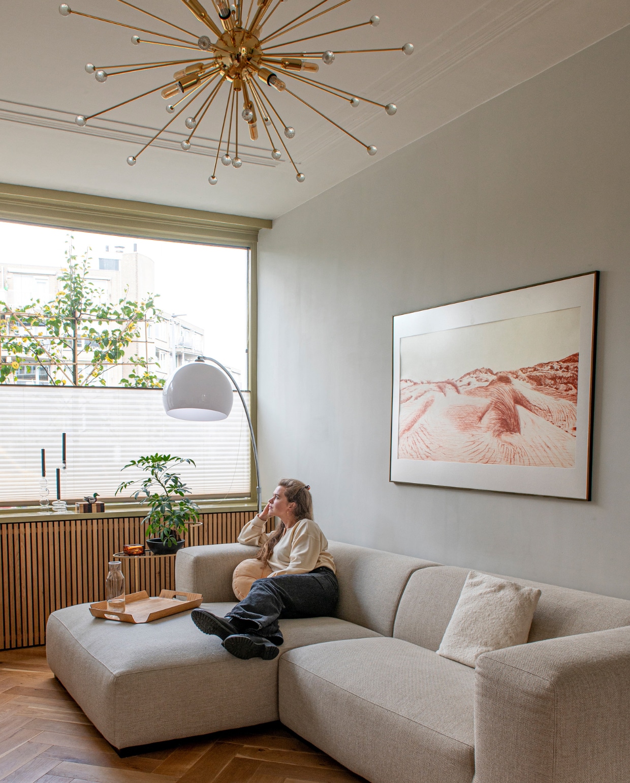 Bank Robin Junior van Koozo, booglamp gered van het grofvuil, hanglamp Sputnik via Catawiki, rond kussen Sissy-Boy, dienblad Madera van Bredemeijer, plisségordijnen Pax Raamdecoratie, tekening zelfgemaakt. Overig onbekend.DIY Pastel- vtwonen special DIY 07-2023 | styling Jeske Weel |  fotografie Caroline Coehorst