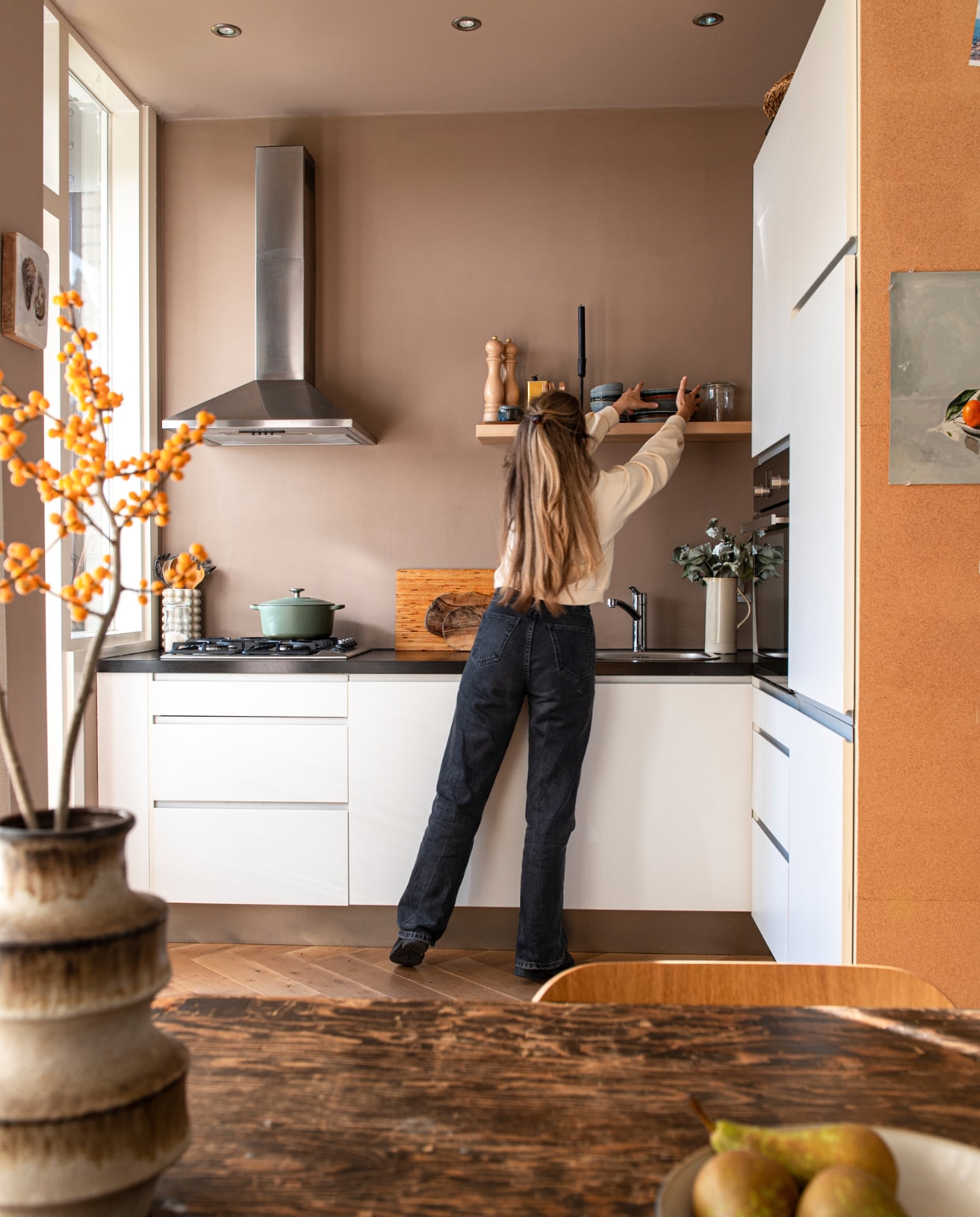 Keuken zat al in het huis, eikenhouten lamelparketvloer Vloer Het Zelf, servies Terres de Rêves van Serax, braadpan Bourgogne van BK, legertafel Marktplaats, stoel PLC van Modus Furniture, vaas vintage, karaf Madam Stoltz, peper- en zoutmolen Peugeot, wandobject zelfgemaakt, wand- en plafondverf Dead Salmon van Farrow &amp; Ball. Overig onbekend. vtwonen special DIY 07-2023 | styling Jeske Weel |  fotografie Caroline Coehorst