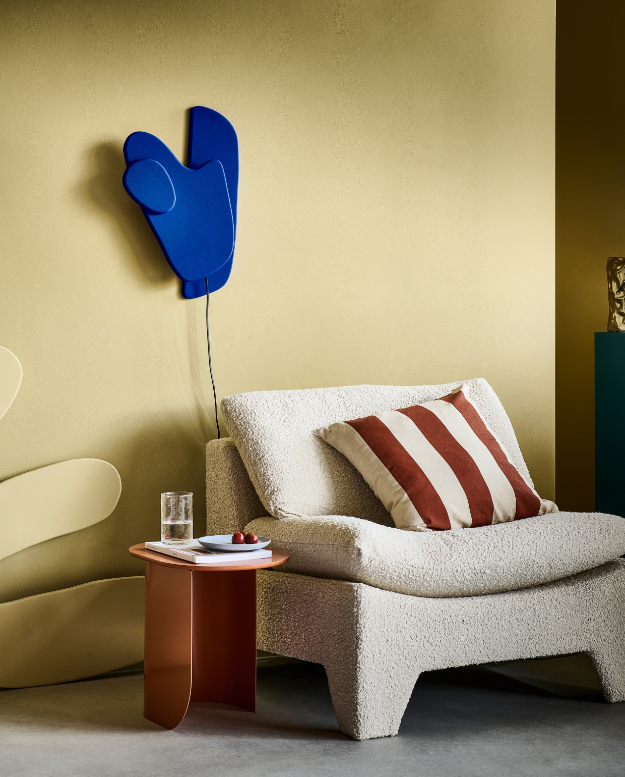 Muurverf Oak Apple, lakverf Ultra Blue (littlegreene.nl). Fauteuil Retro Lounge in bouclé stof, 82x84x76 cm (bxdxh) € 949,-, glazen blauwe pilaar, 28x28x90 cm (bxdxh) € 325,-, metalen vaas Bag of chips 26 cm € 49,95 (hkliving.com). Bijzettafel Plateau in Caramel, hout en metaal € 249,- (festamsterdam.com). Linnen kussenhoes € 12,99, keramieken bord € 9,99 (hm.com). Waterglas € 5,99 (zarahome.com). Tijdschrift privébezit. vtwonen special DIY 07 | styling Sanne Ketelaar | fotografie Sjoerd Eickmans | assistentie Esmee Jacké
