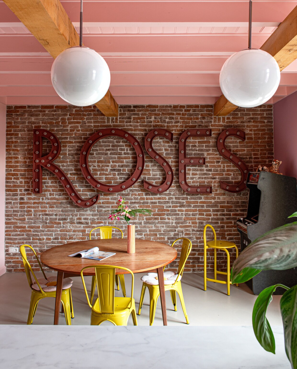 Panter vintage, stoelen Tolix, eettafel Louis van Teeffelen, lampen kringloopwinkel in Denemarken. Gamemachine en muurletters Spektakel Wonen. Vloer van BaseBeton van Poorte Vloer &amp; Wand Design. Wand- en plafondkleuren Zalm en Potpourri van Gamma. vtwonen 11-2023 | productie De Binnenkijkers | styling Jeske Weel | fotografie Caroline Coehorst