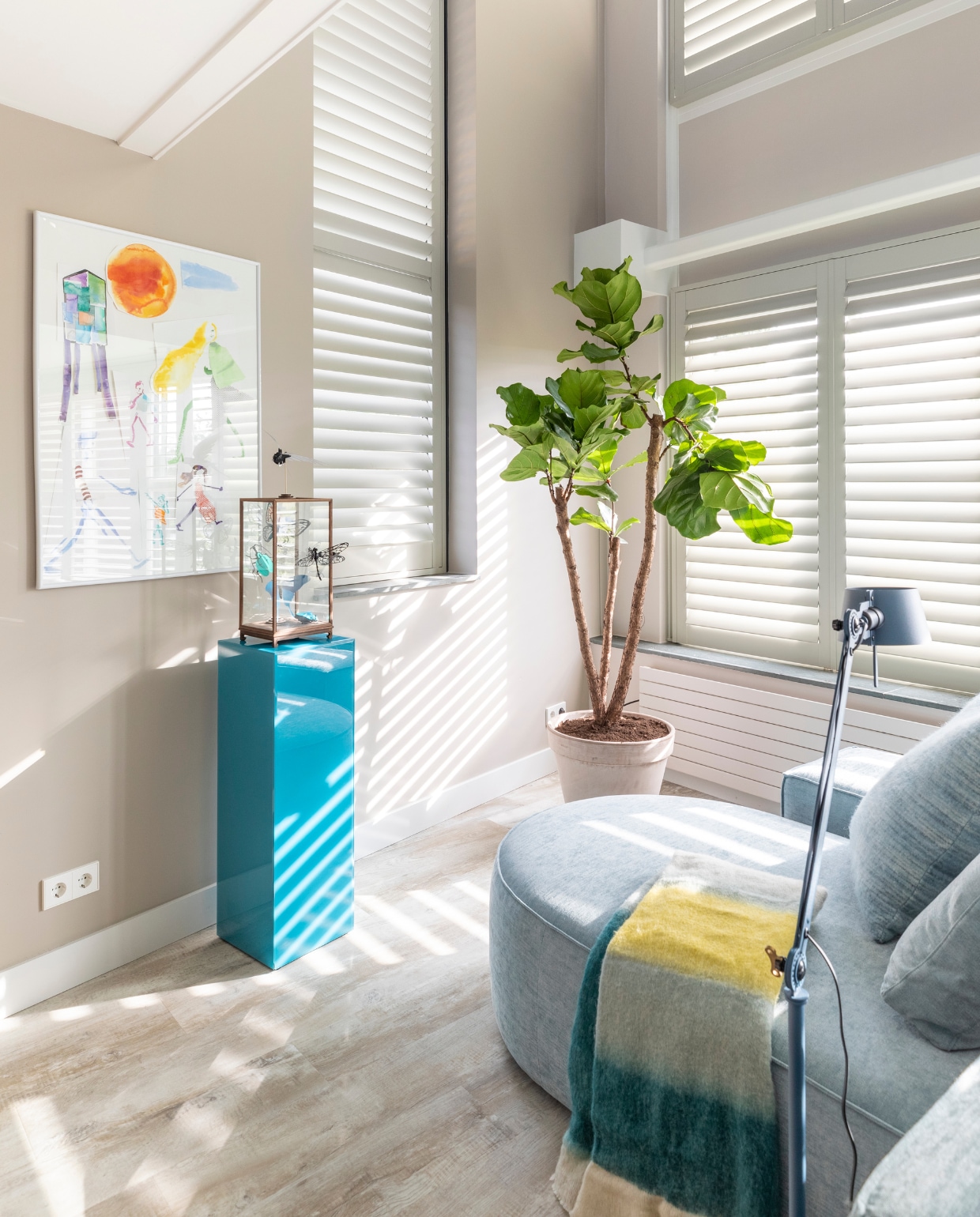 Vloerlamp Bolt van Tonone, blauwe pilaar Mirror van HKliving, lichtblauw kussen van Malagoon, plaid van Malagoon, (eijerkamp.nl). Blauwe metalen bijzettafel van HKliving, Shutters in kleur Cream Grey, prijs op aanvraag (jasnoshutters.nl), plaid van Malagoon (eijerkamp.nl), Elementenbank Loki van Studio Mik. Overig privébezit. vtwonen weer verliefd op je huis seizoen 15 aflevering 10 | styling Marianne Luning | fotografie Margriet Hoekstra