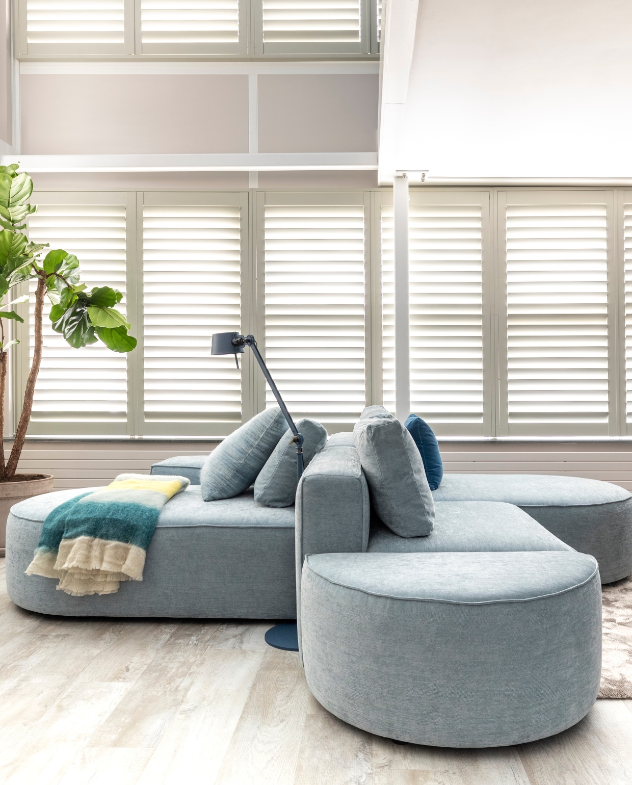 Flexa Creations muurverf bij wand met shutters Sandy Steps, Shutters kleur Cream Grey, prijs op aanvraag (jasnoshutters.nl), elementenbank Loki van Studio Mik € 4683,-, vloerlamp Bolt van Tonone € 450,-, vloerkleed Haven van Bic Carpets op maat gemaakt, prijs op aanvraag (eijerkamp.nl). Blauwe bijzettafel van HKliving € 249,-, crèmekleurige bijzettafel van HKliving € 149,-, donkerblauw kussen Dot van Hay € 85,-, plaid van Malagoon € 39,95 (eijerkamp.nl). vtwonen weer verliefd op je huis seizoen 15 aflevering 10 | styling Marianne Luning | fotografie Margriet Hoekstra