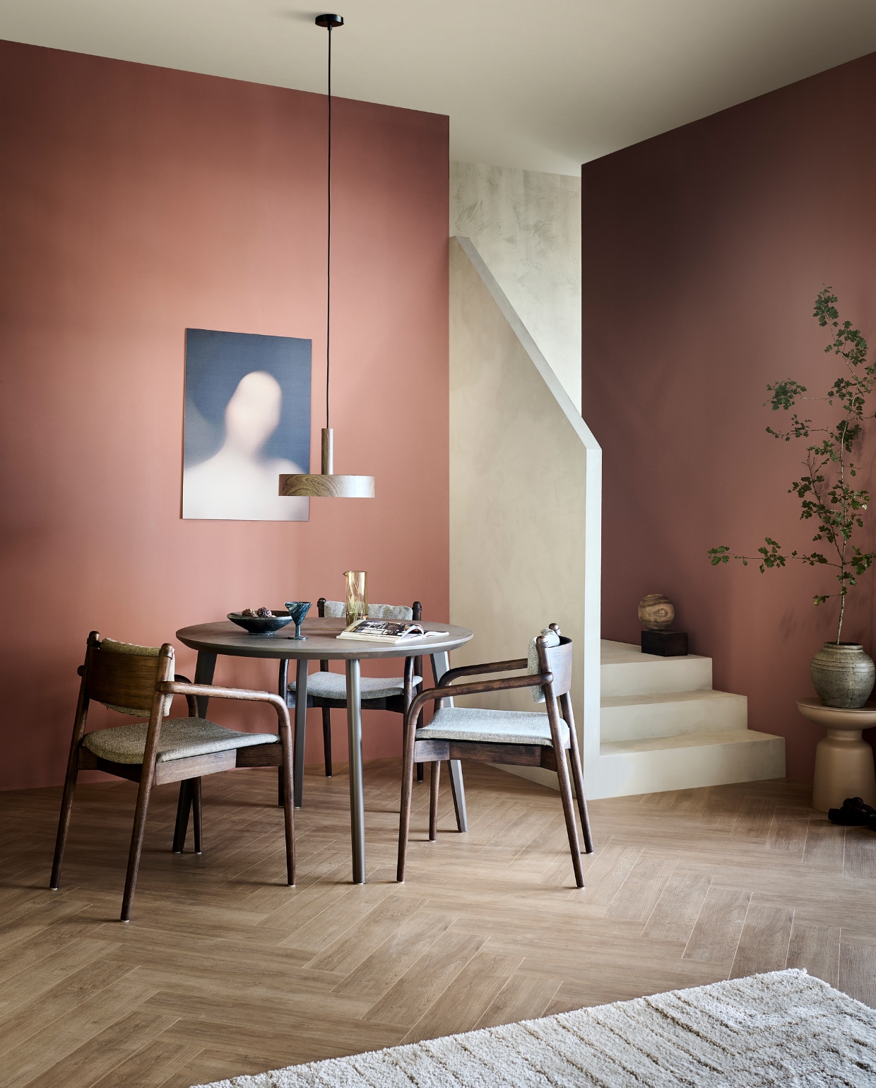 Laminaatvloer Rafter, met groef, inhoud per pak 2,25 m², lamel 138x32,6x0,8 cm, per m² € 32,99, muurverf Blusher, vanaf 1 liter € 27,99, lakverf eettafel Warm Brown, vanaf 500 ml€ 27,99, metalen hanglamp Woody, 35x8 cm (Øxh), excl. lichtbron € 99,-, kunststof vloerkleed Maze, 160x230 cm € 179,-. M.m.v. vtwonen.nl/shop (eetkamerstoelen van Dutchbone), karwei.nl (bijzettafel Yerba), zarahome.com (glazen karaf, stenen bloempot, houten doos met stalen deksel), posterandframe.com (poster Gurilla). Overig privébezit. vtwonen 11-2023 | productie tanja Saarberg | styling Sanne Ketelaar | fotografie Sjoerd Eickmans