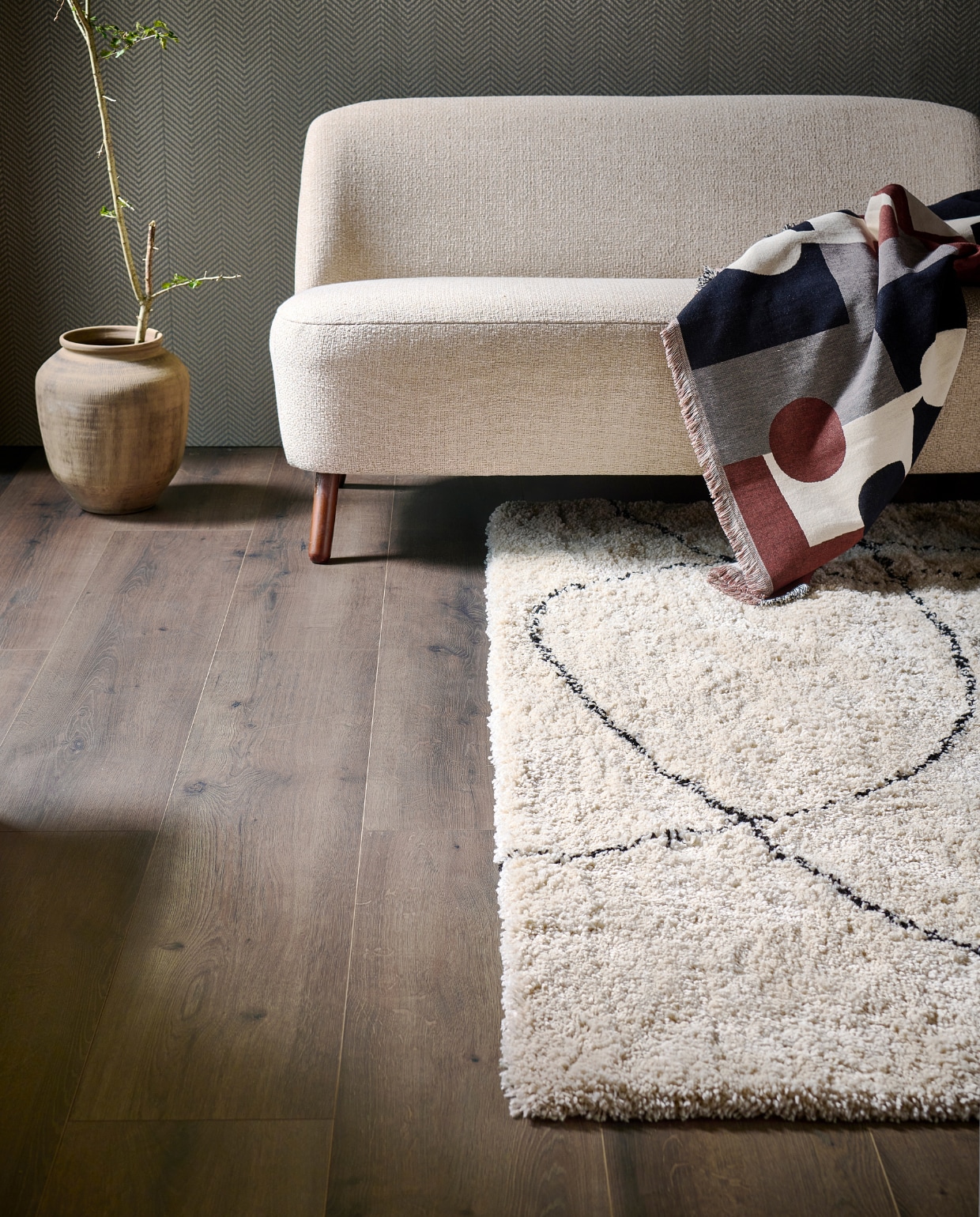 Evc-vloer Rye, incl. ondervloer, lamel 129x24,6 cm, inhoud per pak 2,54 m², per m² € 52,99, kunststof vloerkleed Doodle, 200x290 cm € 279,-.M.m.v. karwei.nl (bank Roan), zarahome.com (stenen bloempot), hm.com (plaid). Overig privébezit. vtwonen 11-2023 | productie tanja Saarberg | styling Sanne Ketelaar | fotografie Sjoerd Eickmans