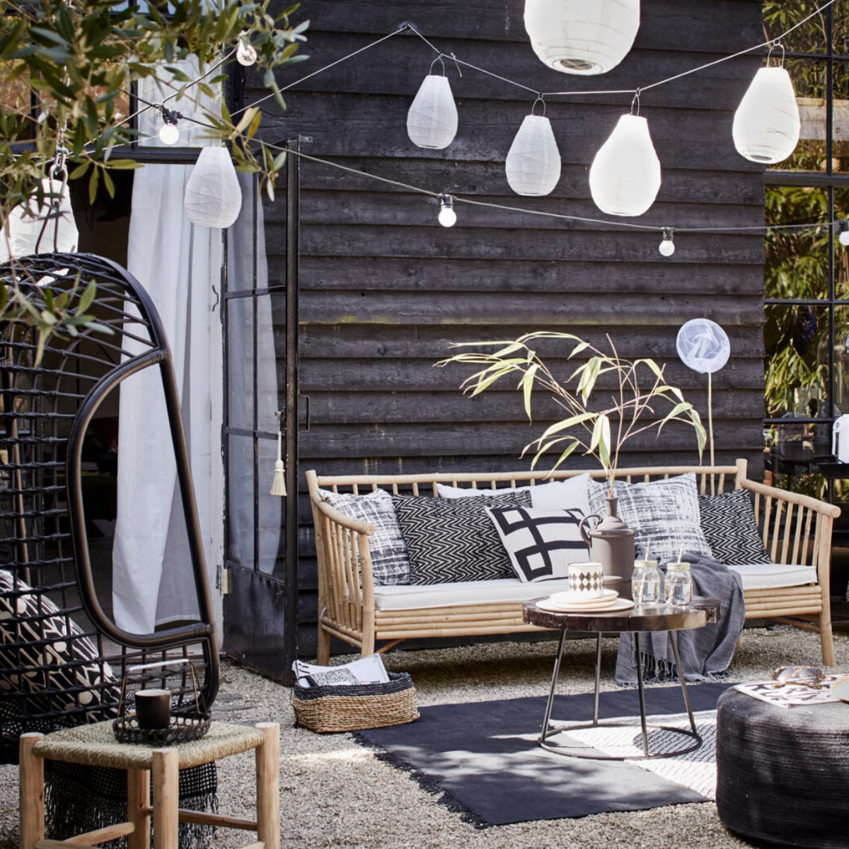 Bamboe bank van Tine K Home, 190 cm breed (l’Etoile Conceptstore). Kussens op de bank van linksaf: hoes met vervaagde ruit, Worn van House Doctor, 50x50 cm, zigzagkussen Graphy van Casa Vivante 60x40 cm, wit kussen met zwart grafisch motief Lifestyle Manhattan 50x30 cm (www.vtwonen.nl). Plaid (Hammam 34). Rotan hangstoel van HK Living (www.vtwonen.nl). Erin kussen Feathers van Littlephant, 50x50 cm (Livv Lifestyle). Plaid (H&amp;M). Marokkaanse gevlochten kruk van HK Living, groot 37x37x42 cm, klein 31x31x25 cm, salontafel Kraton van Dutch Bone, Ø 60 cm; matzwarte vaas van Madam Stoltz, juten poef van HK Living, 30x70 cm (hxØ) (www.vtwonen.nl). Mason Jar drinkbekers set van 4 (vtwonen.nl). Houten bordjes van HK Living, emaillen zwart-wit potje set van 2 (www.vtwonen.nl). Rieten hoed (Sukha Amsterdam). Vloerkleed Stack van House Doctor; zwarte rotan stoel van House Doctor (www.vtwonen.nl). Zwart-wit vloerkleed (H&amp;M). Lampions Drop van House Doctor, 30x20 cm (hxØ) per 2 en 35x24 cm (hxØ) per 2, lichtsnoer Bella Vista van Seletti, 10 lampen, 14,2 meter (www.vtwonen.nl). Visnet (Sissy-Boy Homeland). Gordijn set van 2 (Ikea). Rieten lage manden van Serax set van 3 (www.vtwonen.nl). vtwonen 06-2015 | styling Cleo Scheulderman | fotografie Alexander van Berge