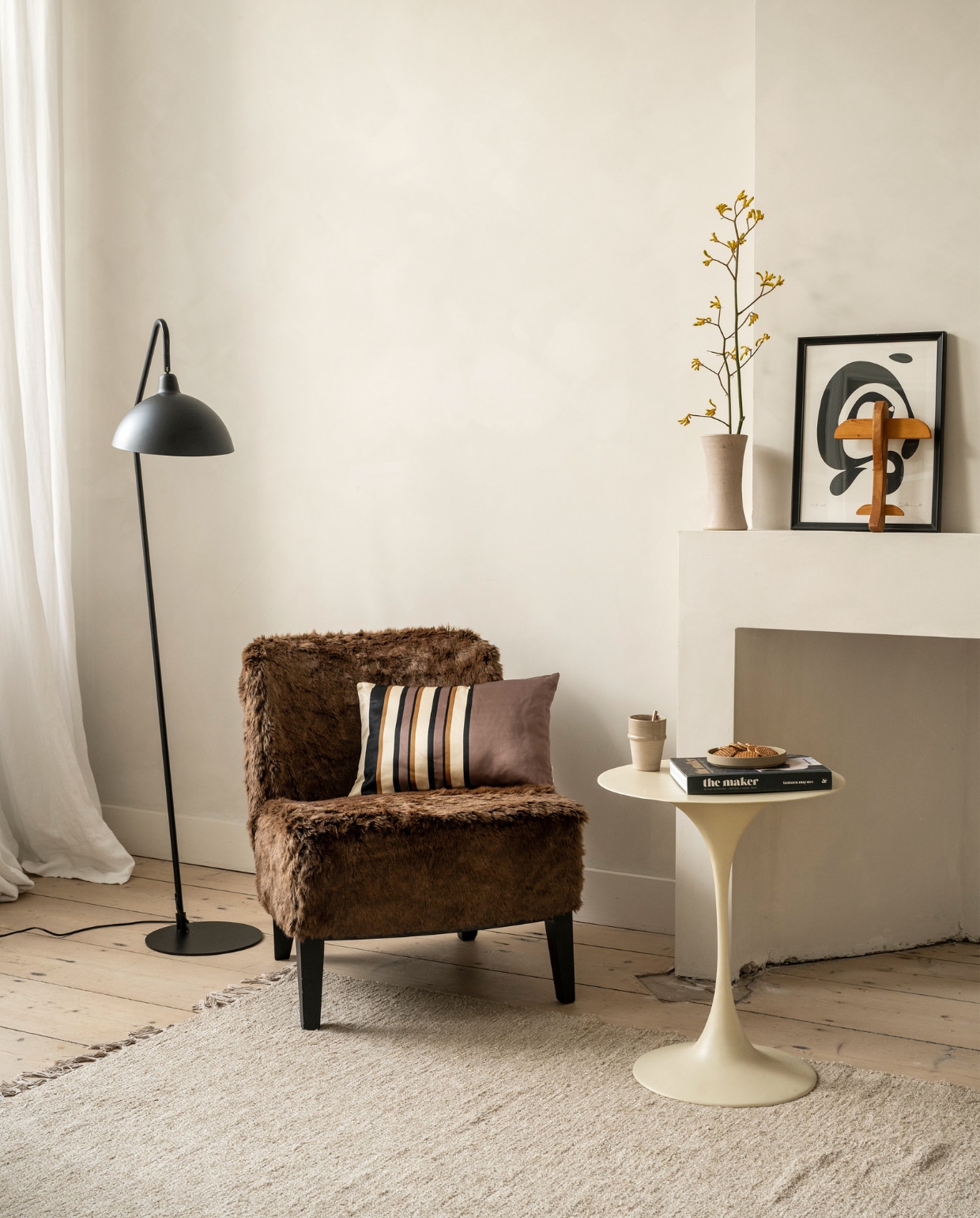 Metalen vloerlamp Orion van vtwonen € 142,95, kussen Rectangular Glossy van vtwonen € 29,95 (vtwonen.nl/shop). Meubelstof vanaf € 79,95 (stof.nl). Bijzettafel en koffiebeker, prijs op aanvraag (householdhardware.nl). Overig privébezit. vtwonen 2023-10 | Styling Fietje Bruijn | Fotografie Stan Koolen