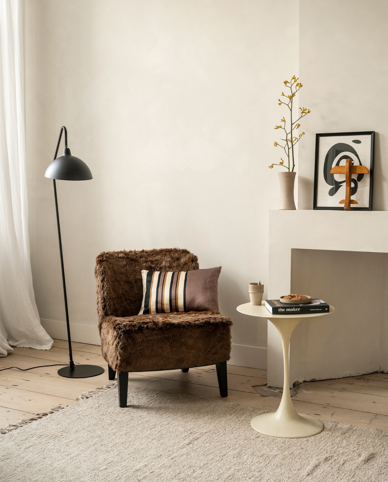 Metalen vloerlamp Orion van vtwonen € 142,95, kussen Rectangular Glossy van vtwonen € 29,95 (vtwonen.nl/shop). Meubelstof vanaf € 79,95 (stof.nl). Bijzettafel en koffiebeker, prijs op aanvraag (householdhardware.nl). Overig privébezit. vtwonen 2023-10 | Styling Fietje Bruijn | Fotografie Stan Koolen