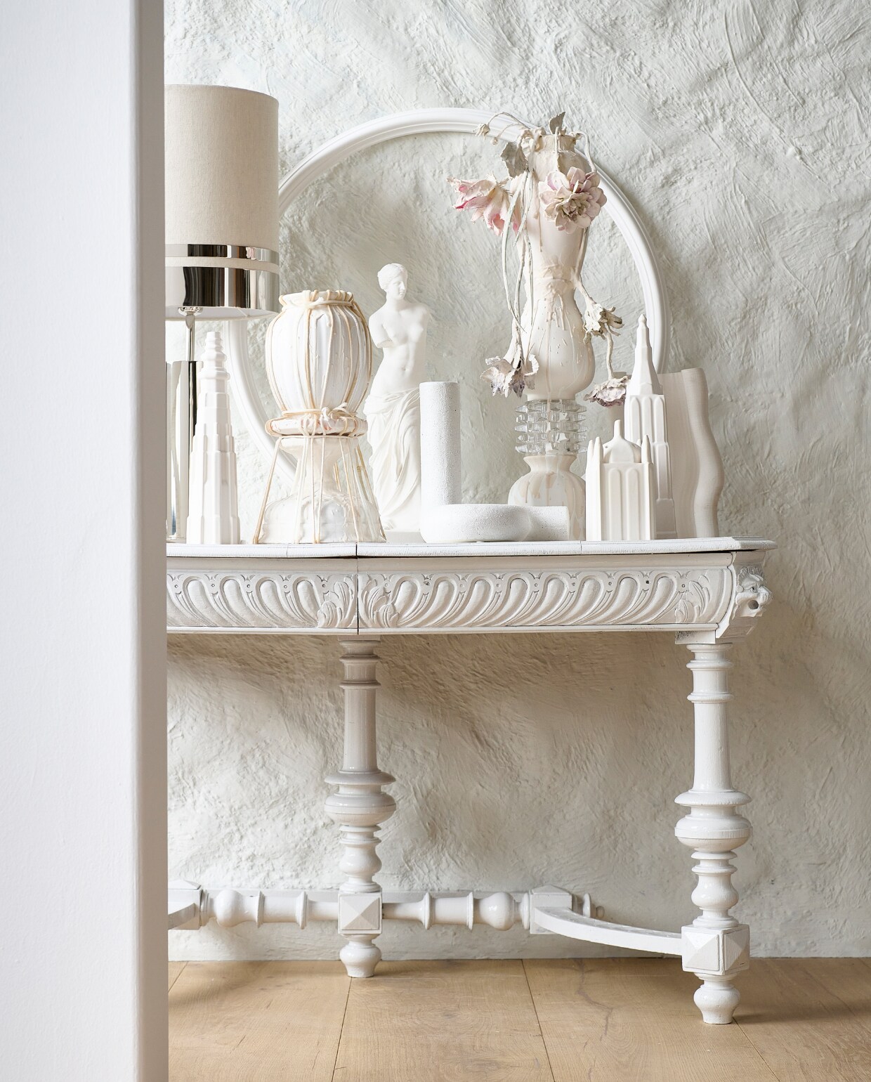 Houten parket XL in geolied eiken white wash van vtwonen, muurverf krijtlook Snow White van vtwonen (karwei.nl). Tweedehands wandtafel (delokatie.nl), geverfd in hoogglans lak White Wood nr. 201 van Lab Paint (vestingh.nl). Kunstobjecten, aardewerk en gerecyclede materialen (vazenvanjanssen.nl). Gipsen cirkel, venusbeeld (het-schippertje.nl). Porseleinen gebouwen van Joost Gijzel (loods5.nl). Overig privébezit. vtwonen 2023-11 | Styling Marianne Luning | Fotografie Sjoerd Eickmans