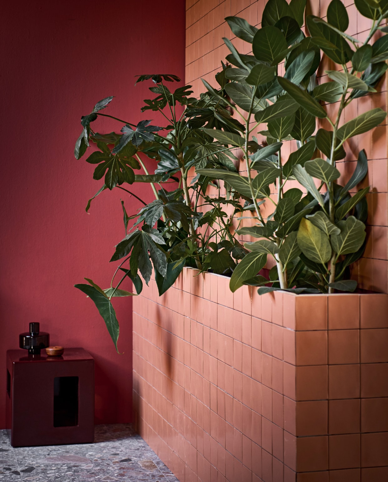 Muurverf Red Earth 1 liter € 27,99. Wand- en vloertegel Composite Brown mat per m2 vanaf € 65,-. Wandtegel Chop in Mattone per m2  vanaf € 79,90. Bijzettafel Modern € 219,-. Glazen vaas € 19,95. vtwonen catalogus 2023