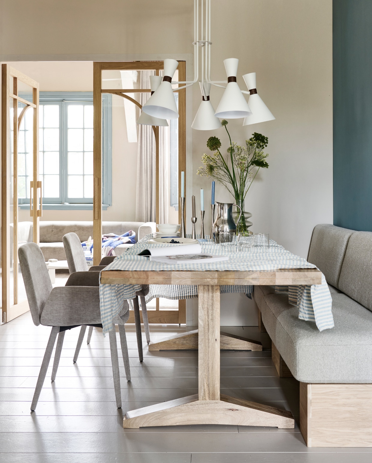 Eetkamerstoel Curve € 199,-. Eettafel Deck € 899,-. Kandelaars vanaf € 16,95. Draaifauteuil Turn € 599,-. Vloerkleed loperformaat Blocks € 239,99. Bijzettafel Coffee A Gogo € 229,-. Tafellamp Monk vanaf € 74,95. Vaas van helder glas € 79,95  Diverse fotolijsten naturel vanaf € 12,95. Tv-meubel Settle Down € 499,-. M.m.v. indudoors.nl (dubbele binnendeur Milaan), wallofart.com (kunstwerken), hay.nl (blauwe en gele opbergdozen), zarahome.com (tafelkleed). Overig privébezit. vtwonen catalogus 2023