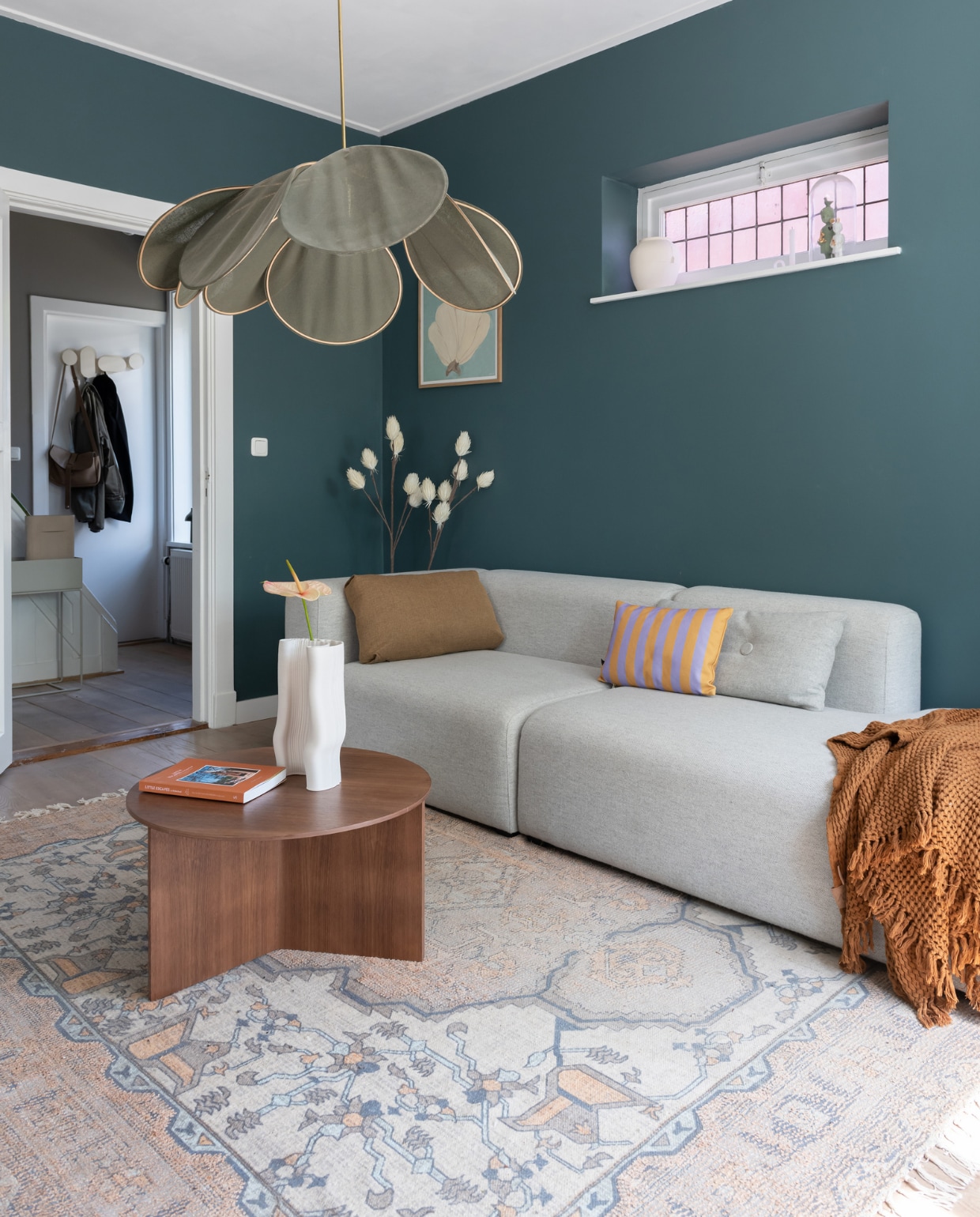 Muurverf Inchyra Blue van Farrow &amp; Ball. Bank en salontafel Hay. Gestreept kussen Fést, vloerkleed HKliving, vaas Ferm Living, hanglamp Georges Store. Overig onbekend. vtwonen 12-2023 | styling Sharon Roest | fotografie Caroline Martinot