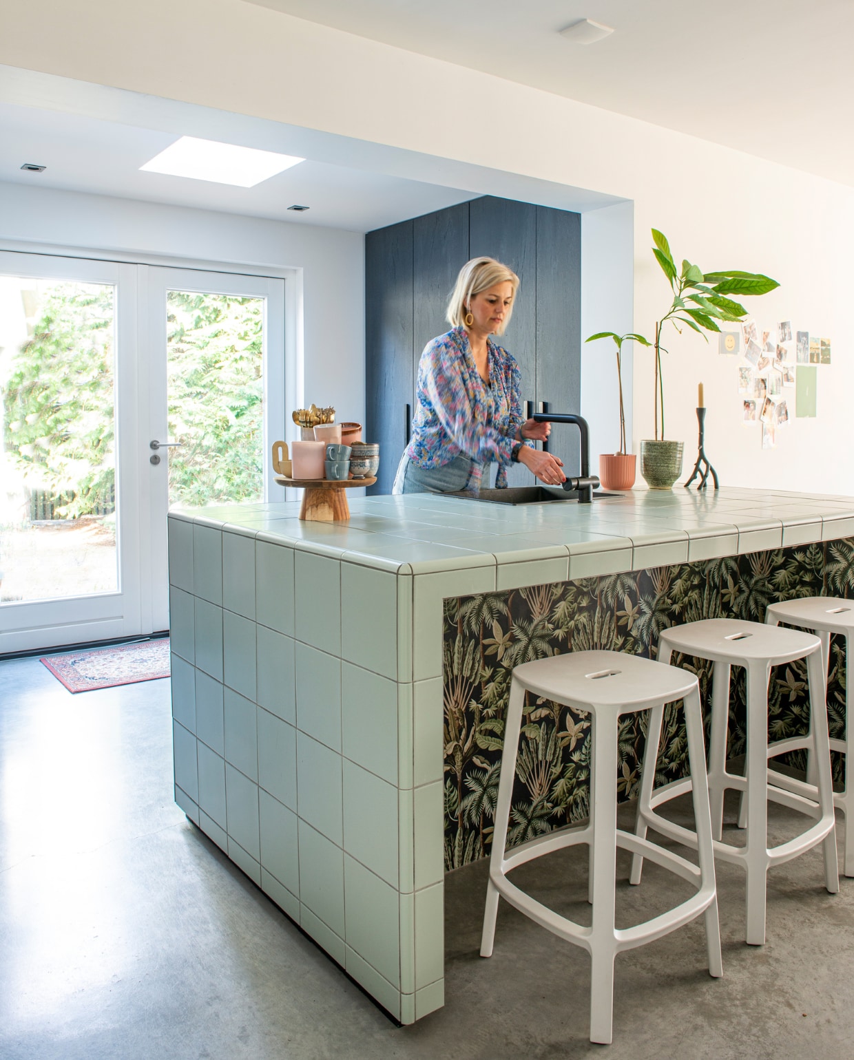 Keuken maatwerk, fronten fineer type FA148 Eiken Balk Mismatch Zwart van Impression Fineer, Italiaanse tegels Edera mat van van Ce.si, behang Sep Groen van Kwantum. Barkruk Cadrea van GewoonStijl. Gevlinderde betonvloer van Indurfloor. Houten plateau en kaarsenstandaard met oor Hema, roze mokken HKliving, gouden bestek Albert Heijn, blauwe kopjes H&amp;M Home. Zwarte spoelbak van Franke, kraan van Caressi. vtwonen special DIY 6-2022 | productie De Binnenkijkers | styling Jeske Weel | fotografie Caroline Coehorst