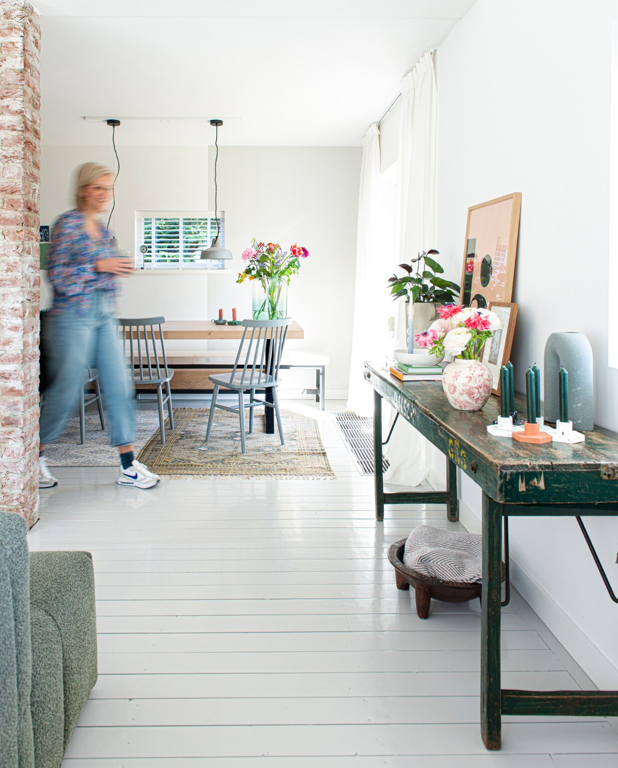 Massief eiken tafel met stalen frame PMP Furniture, stoelen Tressia van Kave Home, op maat gemaakte eettafelbank van wit gebeitste vurenhouten balken en een metalen frame Jorg steigerhout. Betonnen hanglampen Karwei, grote vaas met kleurverloop Kwantum, groene kaarsenstandaards Hema, stonewashed karpet HKliving. Overig zie vorige pagina's. vtwonen special DIY 6-2022 | productie De Binnenkijkers | styling Jeske Weel | fotografie Caroline Coehorst