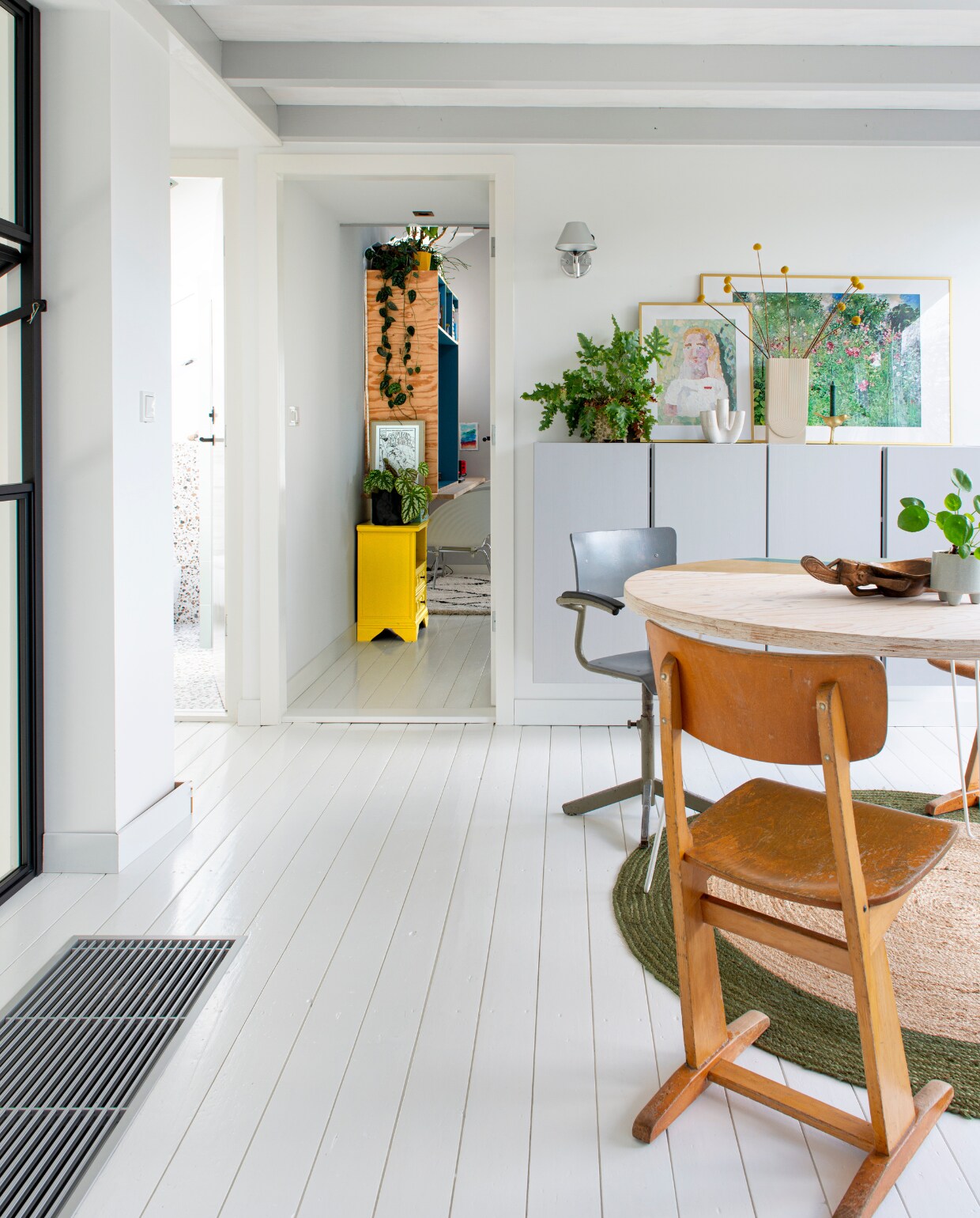 DIY-tafel met hairpin-poten van Karwei, vintage stoelen Marktplaats, zelfgeschilderde wandkasten Ikea. Gouden lijsten van Ikea met knutselwerk dochter en poster van Postery. Juten kleed en vaasjes Karwei, houten schaal meegenomen uit Hawaii, geel kastje Marktplaats, DIY-bureau van plywood. vtwonen special DIY 6-2022 | productie De Binnenkijkers | styling Jeske Weel | fotografie Caroline Coehorst