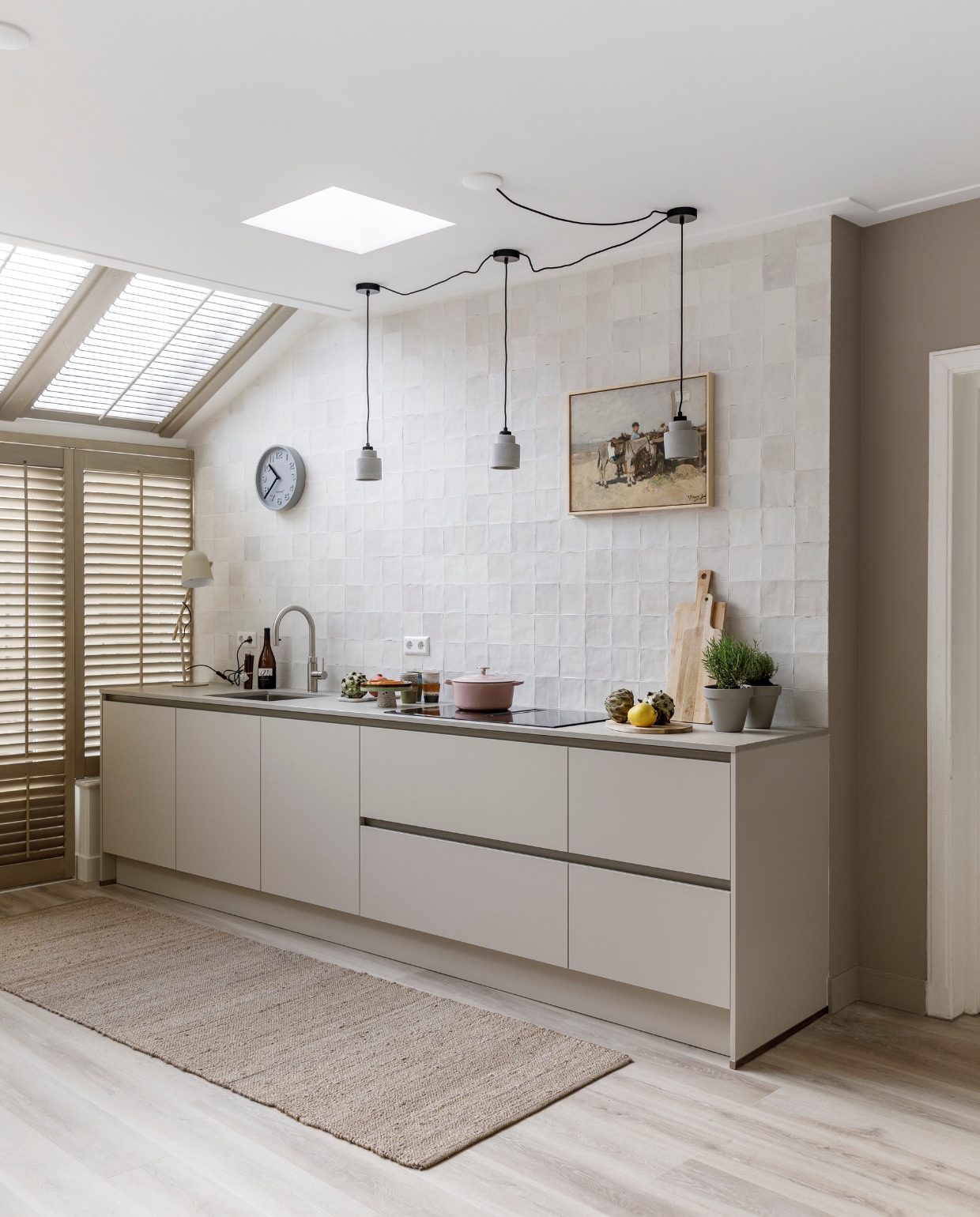 Flexa Easycare Muren muurverf Zandsteenbruin en Flexa Creations lak op lambrisering Zandsteenbruin flexa.nl. Behang uit collectie Embrace 324025 eijffinger.com. Wandtegels vtwonen by Douglas &amp; Jones: Craft Egg White glossy decor, 12,5x12,5 cm, douglasjones.nl. Pvc-vloer met elektrische vloerverwarming woninginrichting-aanhuis.nl. Op maat gemaakte houten shutters in kleur Old White, jasnoshutters.nl. Keuken van vtwonen in kleur Basic Greige mandemakers.nl. Inductiekookplaat PVQ895F25E, compacte oven met magnetron CMG8764C7, stoomoven HSG836NC1 bosch-home.nl. Kunstwerk Ezel op het strand van Scheveningen, Anton Mauve uit de Oude meesters-collectie werkaandemuur.nl. Eettafel, eetkamerstoelen, hanglampen boven tafel en vloerkleed eijerkamp.nl. Eetbank op maat gemaakt en gelakt met blanke lak md-sign.nl. Leren rugkussens in kleur Earth Stone nahka.nl. Hanglampen bij keuken en tafellamp van Zuiver, taartschaal, mokken en marmeren serveerplank van HKliving, roze braadpan Bourgogne van Bk, kandelaar van Bloomingville, bruine glazen vaas van Bloomingville, bruine vaas van HKliving (vtwonen.nl). Klok (zuiver.com). Overig privébezit. Weer verliefd op je huis seizoen 17 aflevering 11 | styling Fietje Bruijn | fotografie Margriet Hoekstra