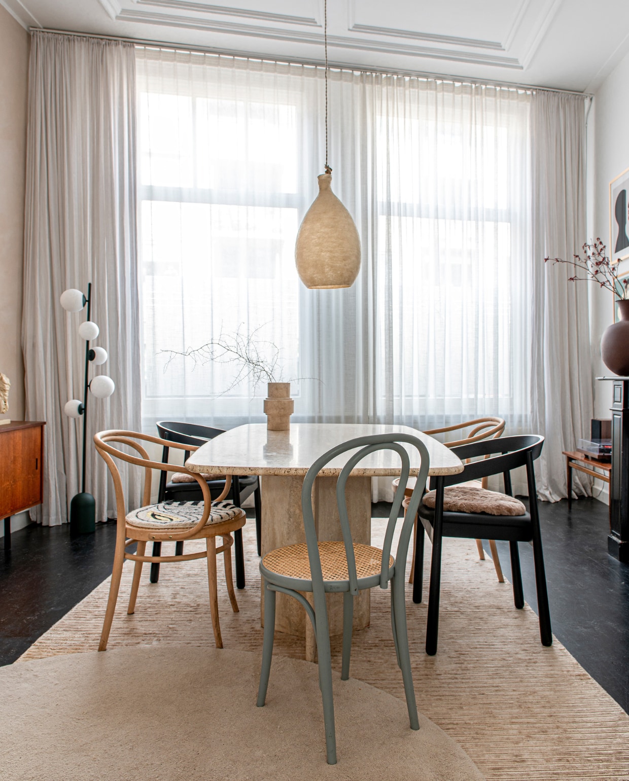 Eettafel Marktplaats. Zwarte stoelen en vloerlamp Kaktee van Fést. Andere stoelen en dressoir vintage. Gordijnen hingen er al, muurverf Kalkliter, soortgelijke hanglamp Vilt aan Zee, vloerkleden Ferm Living. Overig onbekend. vtwonen 12-2023 | productie De Binnenkijkers | styling  Jeske Weel | fotografie Caroline Coehorst