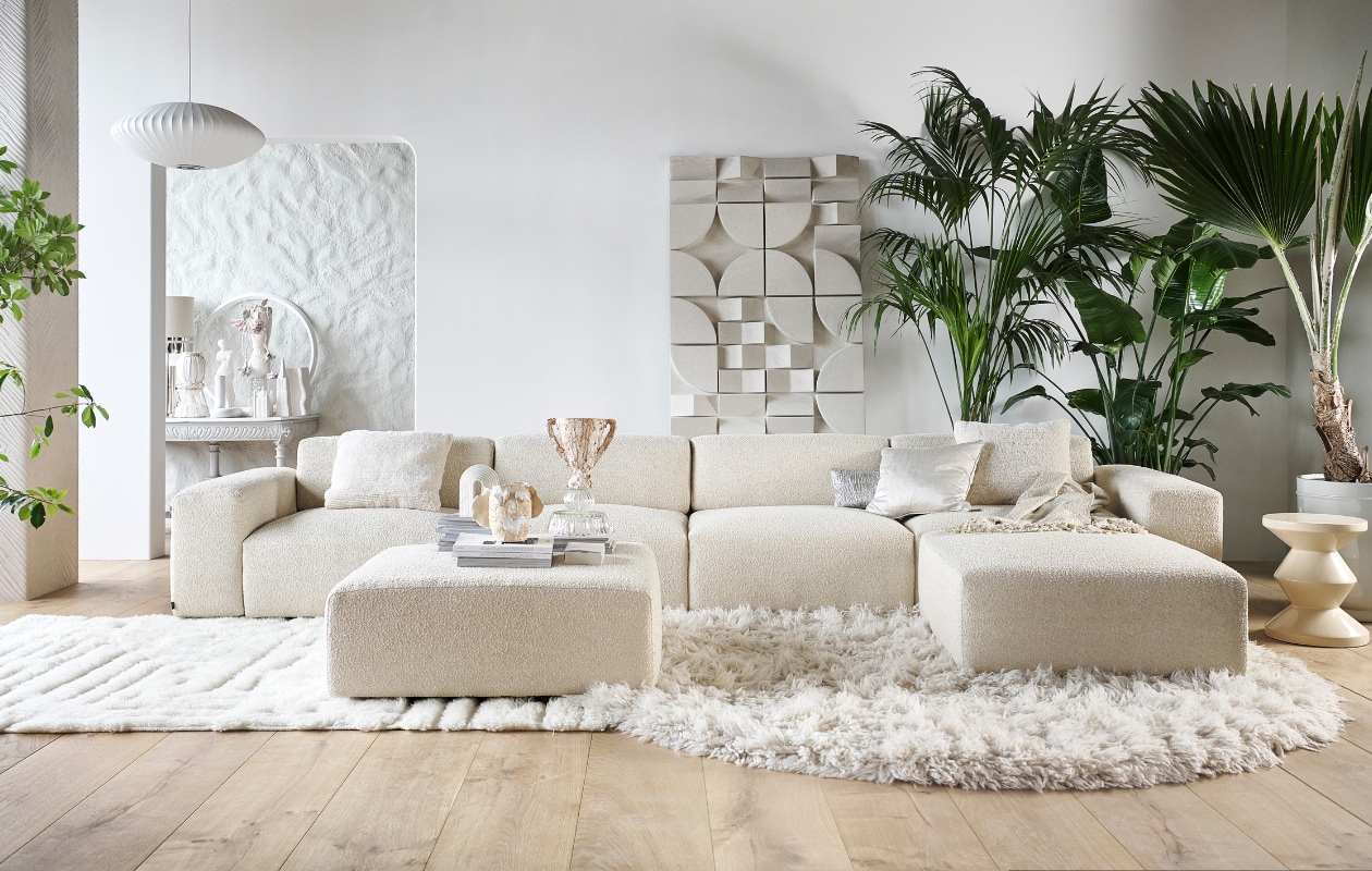Elementenbank Cubi Spacious en poef Large, allebei van Basta in Linen Melé (basta.co). Houten parket XL in geolied eiken white wash van vtwonen en muurverf krijtlook Snow White van vtwonen (karwei.nl). Hoogpolig vloerkleed Fluffy, wol en katoen (hkliving.nl). Wollen vloerkleed van Brinker Carpets, hoog- en laagpolig (eijerkamp.nl). Wandpaneel Montañas (lanena-home.com). Polyester bijzettafel Zig Zag van Polspotten, hanglamp Nelson Saucer Bubble van Hay, acryl plaid Solid van Malagoon in Ivory en aardewerken vaas Moire van Ferm Living (vtwonen.be/shop). Wollen kussen Tufted Solid (malagoon.com). Zilveren katoenen kussen New Age van HKliving en porseleinen gebouwen van Joost Gijzel (loods5.nl). Zijdeglanzend kussen en aardewerken plantenpot (nordal.com). Marmeren boekensteun Ferro van Nordal (deens.nl). Tweedehands wandtafel (delokatie.nl), geverfd in hoogglans lak White Wood nr. 201 van Lab Paint (vestingh.nl). Kunstobjecten, aardewerk en gerecyclede materialen (vazenvanjanssen.nl). Gipsen cirkel en venusbeeld (het-schippertje.nl). Overig privébezit. vtwonen 11-2023 | styling Marianne Luning | fotografie Sjoerd Eickmans