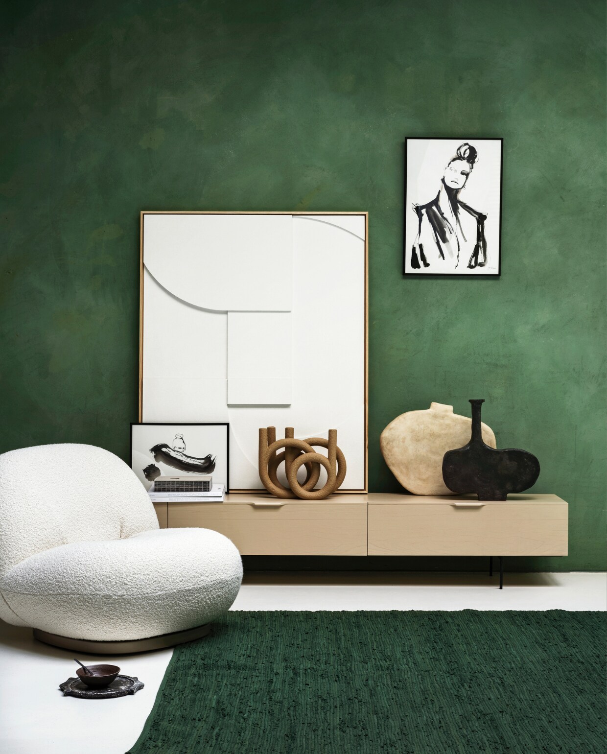 Wollen fauteuil van Gubi, dressoir van HKliving, 167x30x36 cm (bxdxh), witte reliëfkunst van HKliving, zandkleurige kandelaar van Pt, zwarte theelepel van vtwonen, per 6(vtwonen.nl). Groen katoenen vloerkleed, 170x240 cm (loods5.nl). Zwart-witte kunstwerken van Sella Molenaar (thewhitedoorstudio.nl). Vazen van Willem van Hooff (willemvanhooff.com). Zwarte kom van HKliving (hkliving.nl). Kalkverf Lagune, (cartecolori-dialma.nl). Overig privébezit. vtwonen 01-2021 | styling Marianne Luning | fotografie Stan Koolen
