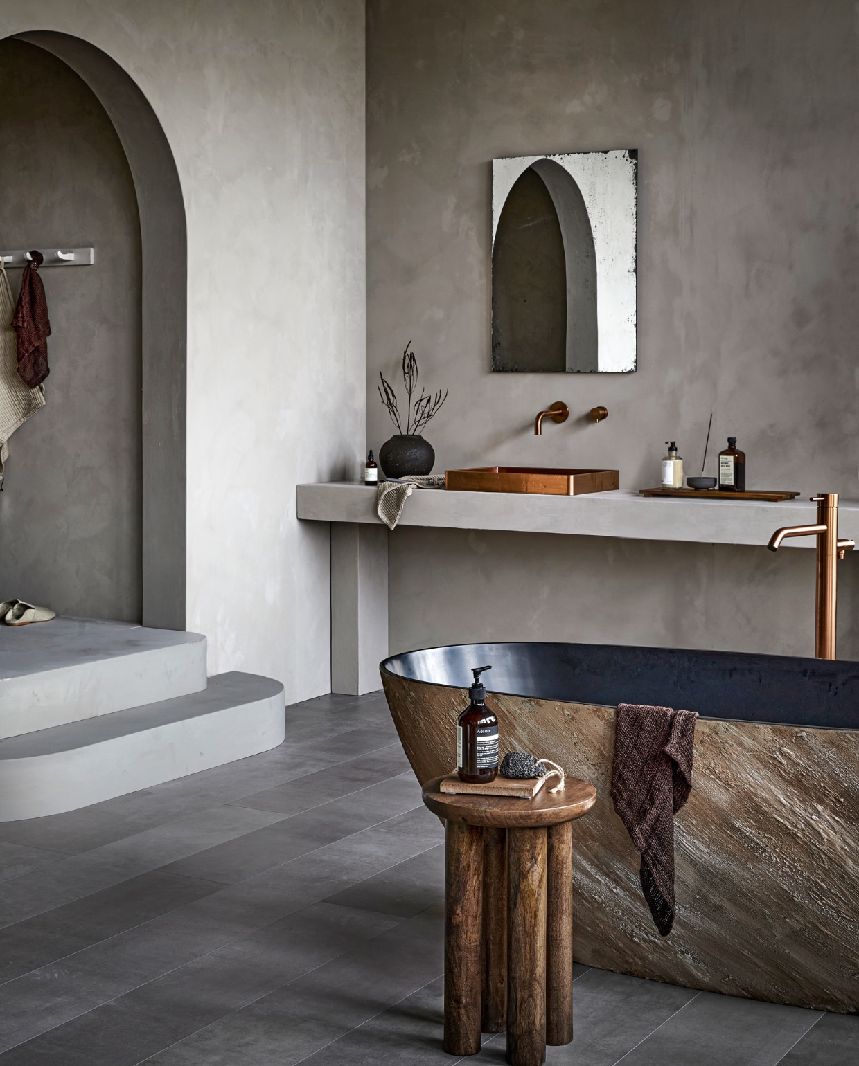 vtwonen collectie (evc-vloer Pebble) pure-original.nl (muurverf Fresco in kleur Soft Taupe), filiaal4.nl (bad, wastafel in Copper, wastafelkraan en badkraan Slimline in Brons), nordal.eu (houten bijzettafel, handdoeken), letoile.store (stenen onderzetter, handzeep, wierookhouder, wierook), paviljoennoord.com (spiegel), zarahome.com (slippers, grijze handdoek, vaas, houten dienblad). Overig privébezit. vtwonen 07-2022 | styling Danielle Verheul | fotografie Peggy Janssen