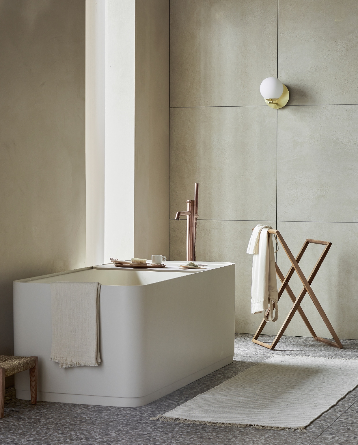 vtwonen collectie (Top solid bad Soft Edge in zand inclusief plateau, 160x73x59,5 cm (lxbxh), 200 liter, ook in wit, grijs en zwart. Vloer: vloer- en wandtegel Terrazzo Clay Flakes, 90x90 cm. Achterwand: vloer- en wandtegel Raw Sand Mat, 80x80 cm). plieger.nl (badkraan Roma), vestingh.nl (muurverf Ibiza Rush van Lab Paint), vtwonen.nl/shop (wandlamp van Trio), zarahome.com (kledingrek, dienblad, zeepschaaltje, kruk), dille-kamille.nl (wasborstel, badzout), hm.com (handdoek, badmat, kopje). Overig privébezit. vtwonen 05-2023 | styling Sanne Ketelaar | fotografie Peggy Janssen