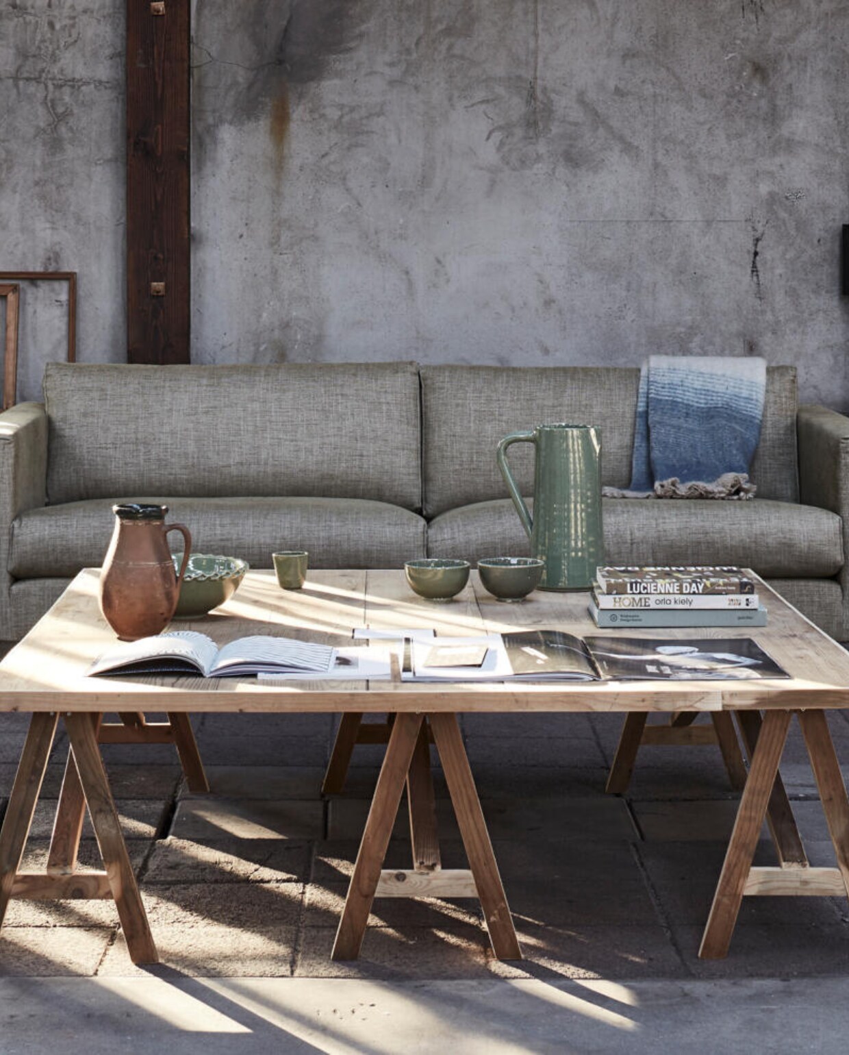 Tafel 140x140x43 cm (bxlxh), op maat gemaakt (Combitex). 2,5-zitsbank Bruce, 185x75x93 cm (bxhxd) (Bodilson). Oude houten lijsten (Neef Louis). Grote flesvaas, kan met donkere rand (Van Dijk &amp; Ko). Manden per 2 (HKliving). Keramische kan, kom, espressokop, schaal, plaid 125x150 (De Weldaad). Groot opengeslagen magazine #mag59 no. 14 (Polspotten). Overig privébezit. vtwonen 04-2016 | styling Fietje Bruijn | fotografie Alexander van Berge