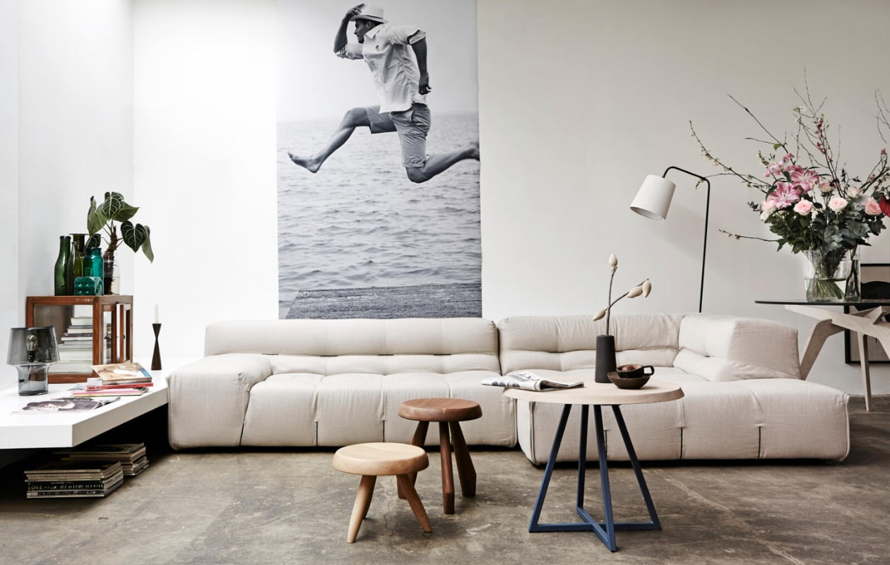 Foto van Eline Klein (http://elineklein.nl). De afdruk 125x245 cm (Eyes on Media). Bank Tufty Time van B&amp;B Italia, tafel Mun1 van Slowwood met blauw onderstel, houten krukjes (Edha Interieur). Donkergrijs glazen lampje (Nordic New). Vitrinekastje (Raw Materials). Groene flessen (Nijhof). Tafel naast de bank (Parry). Staande lamp privébezit. vtwonen 04-2013 | Styling Fietje Bruijn | Fotografie Alexander van Berge
