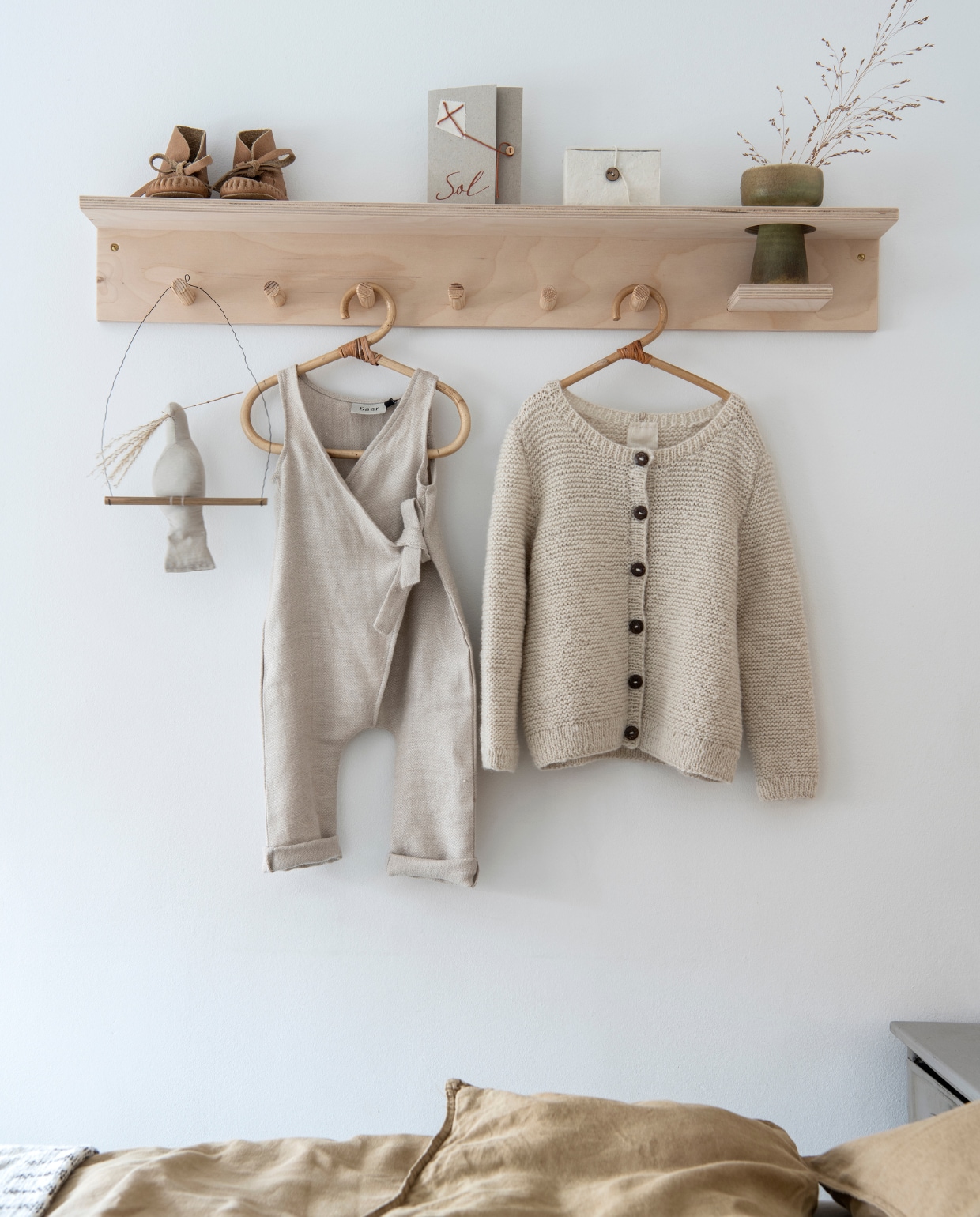 Kapstok Woodchuck. Vogel Fabels Out of Vintage. Salopette Saar. Vestje Atelier Sukha. Rotan kledinghangers Lille Niek. Vaas kringloopwinkel. vtwonen special DIY 3-2021 | productie Inside Homepage | styling Janneke Peters | fotografie Louis Lemaire
