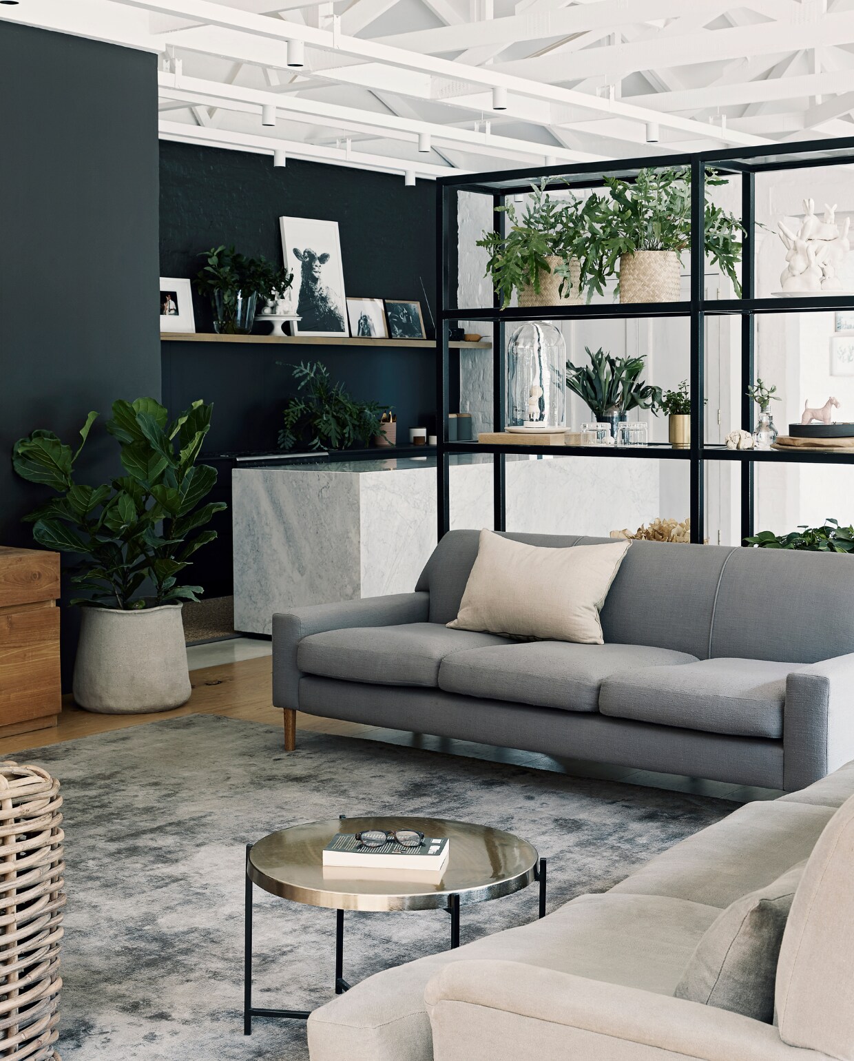 Bank Mezzanine Interiors. Rieten bank Weylandts. Bank rechts en stalen stellingkast Live Simple. Tapijt en ronde bijzettafel Hertex. Plantentafel en bloempotten kringloopwinkel. Overig onbekend. vtwonen binnenkijkspecial 2021 | styling Sven Alberding | fotografie Elsa Young