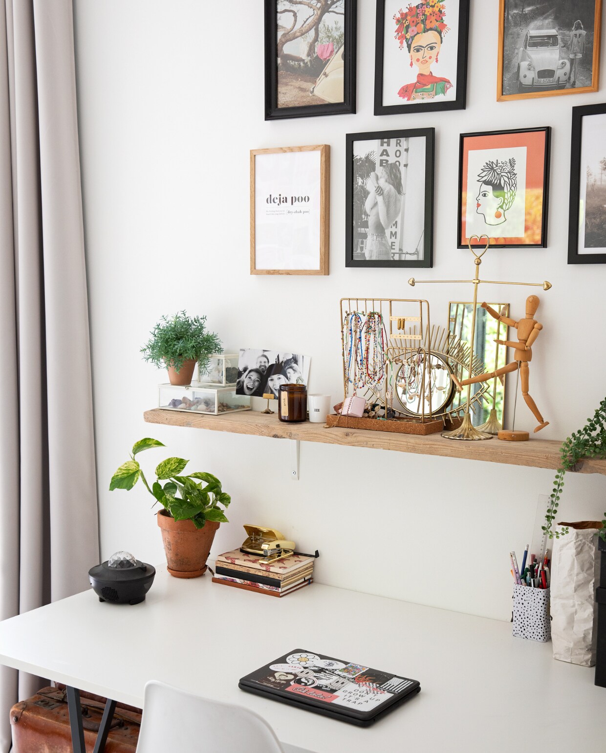 Gordijnen Moondream, muurkleur Ral 9016, lijsten en posters Desenio, foto’s uit tijdschriften, plank Gamma. Op de plank: sieradenhouders uit vintage winkels, spiegels Sissy-Boy, houten tekenpop en planten Xenos. Bureau Ikea, accessoires Hema, stoel Kwantum, koffer van opa. vtwonen 12-2022 | styling Ilona Jongepier | fotografie Dana van Leeuwen