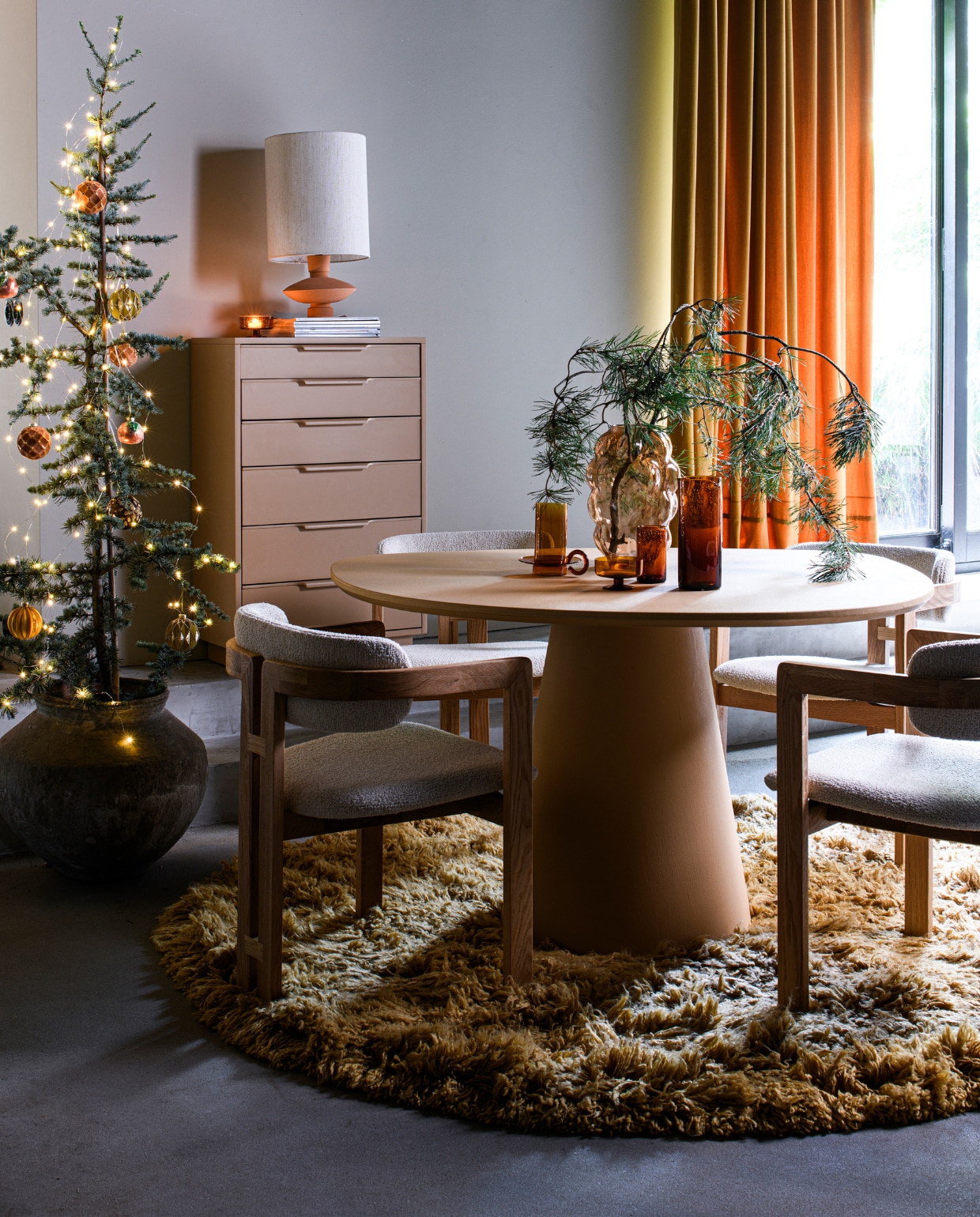 Aardewerken pot € 179,- (rawmaterials.eu). Eettafel, beton en mdf, 130x100 cm (Øxh) € 1357,- (bogard.eu). Eetkamerstoel Grace uit eigen collectie van Loods 5, 57x55x75 cm (bxdxh) € 295,- (loods5.nl). Vloerkleed Fluffy van HKliving, 200 cm (Ø) € 1095,- (villajipp.nl). Glazen vaas Bobbel € 44,99, ballen, per stuk € 2,99, glazen ornament € 2,99 (intratuin.nl). Dessertglas Oli € 25,-, waterglas Oli, klein € 15,- en groot € 19,-, glazen karaf Oli € 39,- (fermliving.com). Kast van HKliving, Sungkai-hout en mdf, 63x33x97 cm (bxdxh) € 950,- (dotshop.nl). Stenen lamp met linnen kap van HKliving, 25x63 cm (Øxh) € 168,- (vtwonen.nl/shop). vtwonen bijlage kerst 2023 | styling Marit Saladini | fotografie Louis lemaire