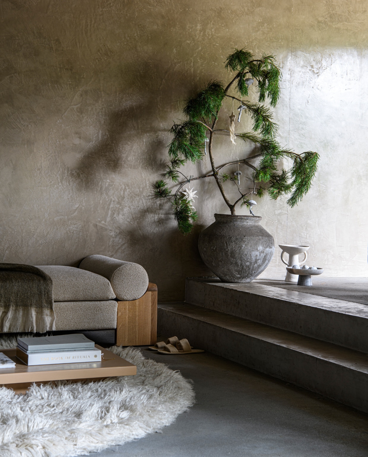Daybed Dya € 995,-, schaal Plateau Paper € 29,95 en schaal Fenne marble € 44,95 uit eigen collectie van Loods 5 (loods5.nl). Plaid Silkuh, 130x170 cm € 59,90, boek € 89,90 (rituals.com). Kleed Fluffy van HKliving, katoen en wol, 250 cm (Ø) € 1575,-, houten salontafel XL Plateau van HKliving, 60x200x12 cm (bxdxh) € 636,- (vtwonen.nl/shop). Aardewerken pot € 179,- (rawmaterials.eu). Papier-maché mushroom ornamenten, set van 4 € 29,-, mushroom ornament € 15,-, stoffen ornamenten Vela Star, per 4 € 29,-, witte snowball ornamenten, per 3 € 19,- (fermliving.com). Wandafwerking marmerlook Coristil, prijs op aanvraag (viaestudio.nl). Overig privébezit. vtwonen bijlage kerst 2023 | styling Marit Saladini | fotografie Louis lemaire
