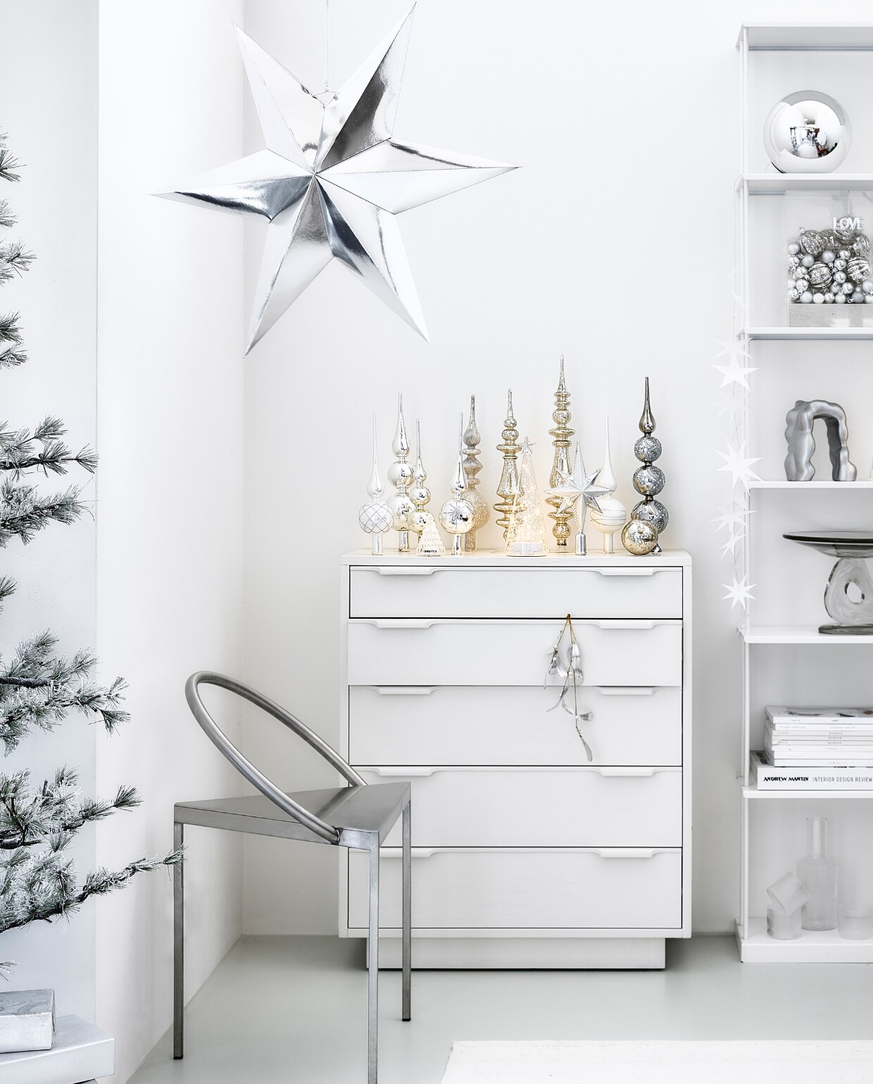 Witte mdf ladekast, 74x33x88 cm (bxdxh) € 995,-, rechthoekige plexiglas stolp met linnen voet, 20x12x30 cm (bxdxh) € 89,95 (hkliving.com). Wolmix tapijt, 160x230 cm € 199,- (zarahome.com). Rvs stoel Triangolo, 48x40x72 cm (bxdxh) € 1185,- (framacph.com). Zilverkleurige papieren ster, 60 cm € 19,95, aluminium ornament Morf van Ferm Living € 135,-, glazen etagère Damo van Ferm Living € 239,-, geribbelde glazen karaf van Ferm Living € 39,-, geribbelde glazen van Ferm Living € 39,- (vtwonen.be/shop). Mistletoe € 22,50 (bungalow.dk). Pieken van links naar rechts: 1, 4, 9 van House of Seasons € 12,95 (bol.com). 2, 3, 5, 8, 10 vanaf € 5,85 (allesinwonderland.nl). 6 en 7 van House of Seasons vanaf € 24,95 (fonq). Geribbelde ledkerstboom Lucy van Sirius, set van 2 € 28,75, glazen ledboom Sweet van Sirius € 23,95, papieren sterrenslinger van Räder € 16,95, kerstboom Alfi Tree van Sirius, 150 ledlampjes, 180 cm (h) € 275,- (two-gether.nl). Glazen kerstbal van House of Seasons € 2,95 (fonq.be). Zilveren bal van House of Seasons, 25 cm (Ø) € 17,95 (bol.com). Kleine ballen van House of Seasons, set van 24 € 14,95 (bol.com). Geribbelde ballen, set van 2 € 7,99 (hm.com). Kersthanger love € 5,50 (kerstenbv.nl). Inpakpapier € 2,95 (vliegerpapier.nl). Overig privébezit. vtwonen bijlage kerst 2023 | styling Kim van Rossenberg | fotografie Sjoerd Eickmans