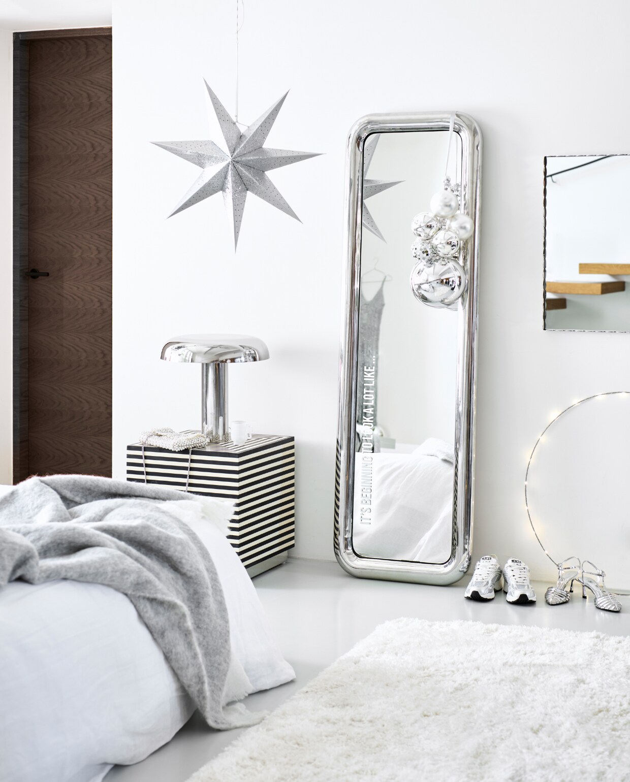 Staande spiegel Chubby met chromen rand, 170x53x7,5 cm (hxbxd) € 995,-, verchroomde tafellamp Mushroom, 39x39x38 cm (lxbxh) € 269,- (hkliving.com). Spiegel Rectangle met geschulpte stalen rand, 43,5x61,5 cm € 419,- (hay.dk). Zwart-wit gestreepte kubustafel Taura, mdf met mangohout, 46x46x47 cm € 681,82, grijze mohair plaid € 99,95 (nordal.eu). Papieren kerstster, 60 cm € 9,95, verlichte cirkel van Luca Lighting, 70 cm € 59,95, onbreekbare ballen van House of Seasons, 25 cm (Ø), set van 6 € 17,95 (bol.com). Vloerkleed, 150x200 cm € 179,-, wit linnen dekbedovertrek, 220x240 cm € 89,99 (zarahome.com). Zilveren gympen van gerecycled materiaal € 169,- (merceramsterdam.com). Zilveren dansschoenen € 22,99, tas € 45,95 (hm.com). Tros kerstballen: onbreekbare grote bal van House of Seasons, 25 cm (Ø) € 17,95, glazen kerstballen, 10 cm (Ø), set van 4 € 12,95, kleine onbreekbare kerstballen van House of Seasons, set van 24 € 14,95 (bol.com). Mozaïek kerstbal € 7,95 (vtwonen.nl/shop). Witte glazen mok € 49,- (mekstyling.com). Plakletters metallic zilver in lettertype Bebas Neue € 11,86 (stickey.nl). vtwonen bijlage kerst 2023 | styling Kim van Rossenberg | fotografie Sjoerd Eickmans