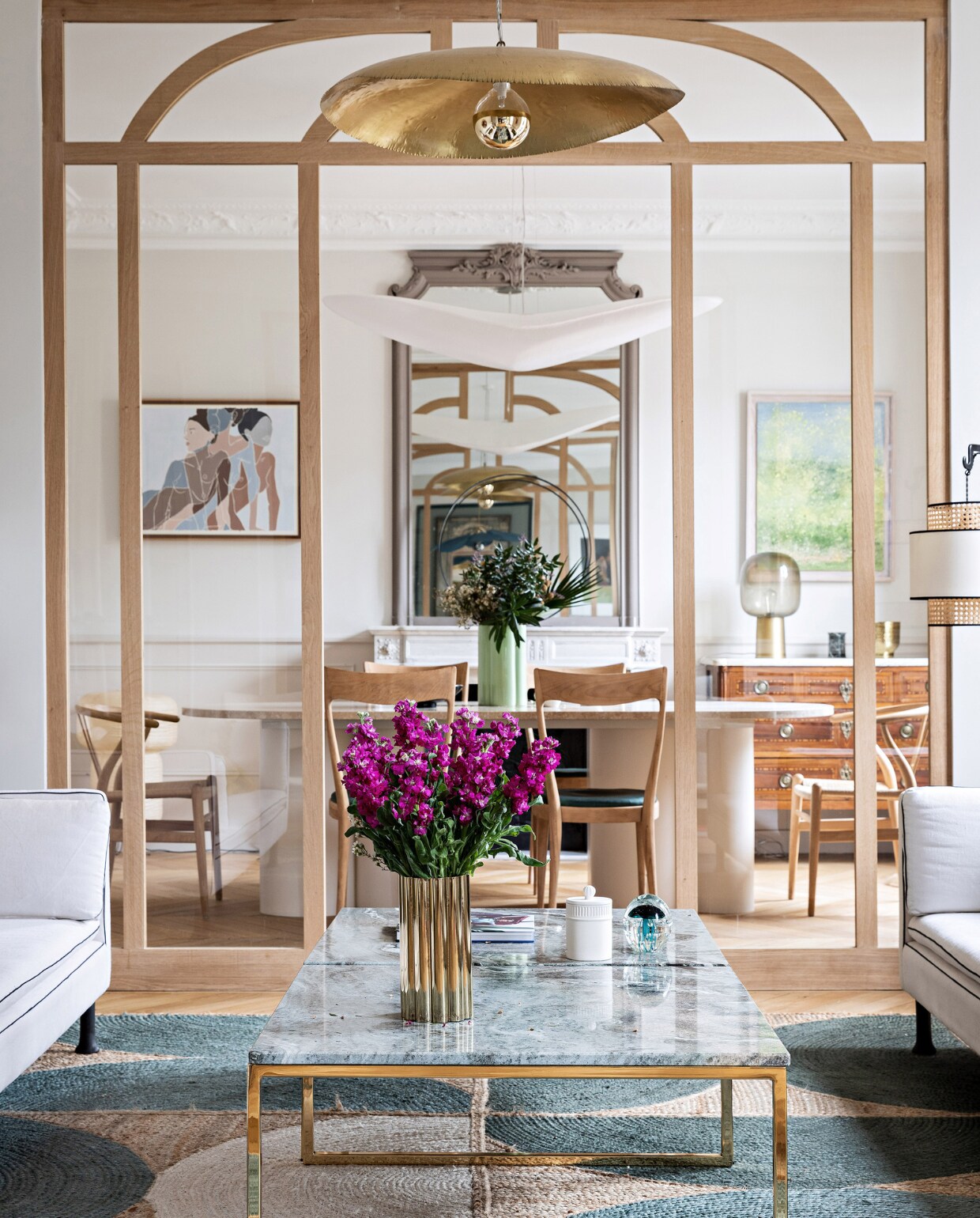 Stenen tafel en salontafel op maat gemaakt door Bateaumagne. Stoelen rommelmarkt in Normandië, hanglamp Céline Wright, schilderij links Faustine Badrichani, schilderij rechts Antoine Vit. Ladekast en spiegel erfstuk. Gouden vaas en glazen vaas H&amp;M Home. Groene vaas India Mahdavi, vloerkleed Rocky van Élitis, gouden hanglamp Brass 95 van Paola Navone voor Gervasoni. Overig onbekend. vtwonen 12-2023 | productie AC Scoffoni | styling Marie-Maud Levron | fotografie Yann Deret | tekstbewerking Merel van der Lande