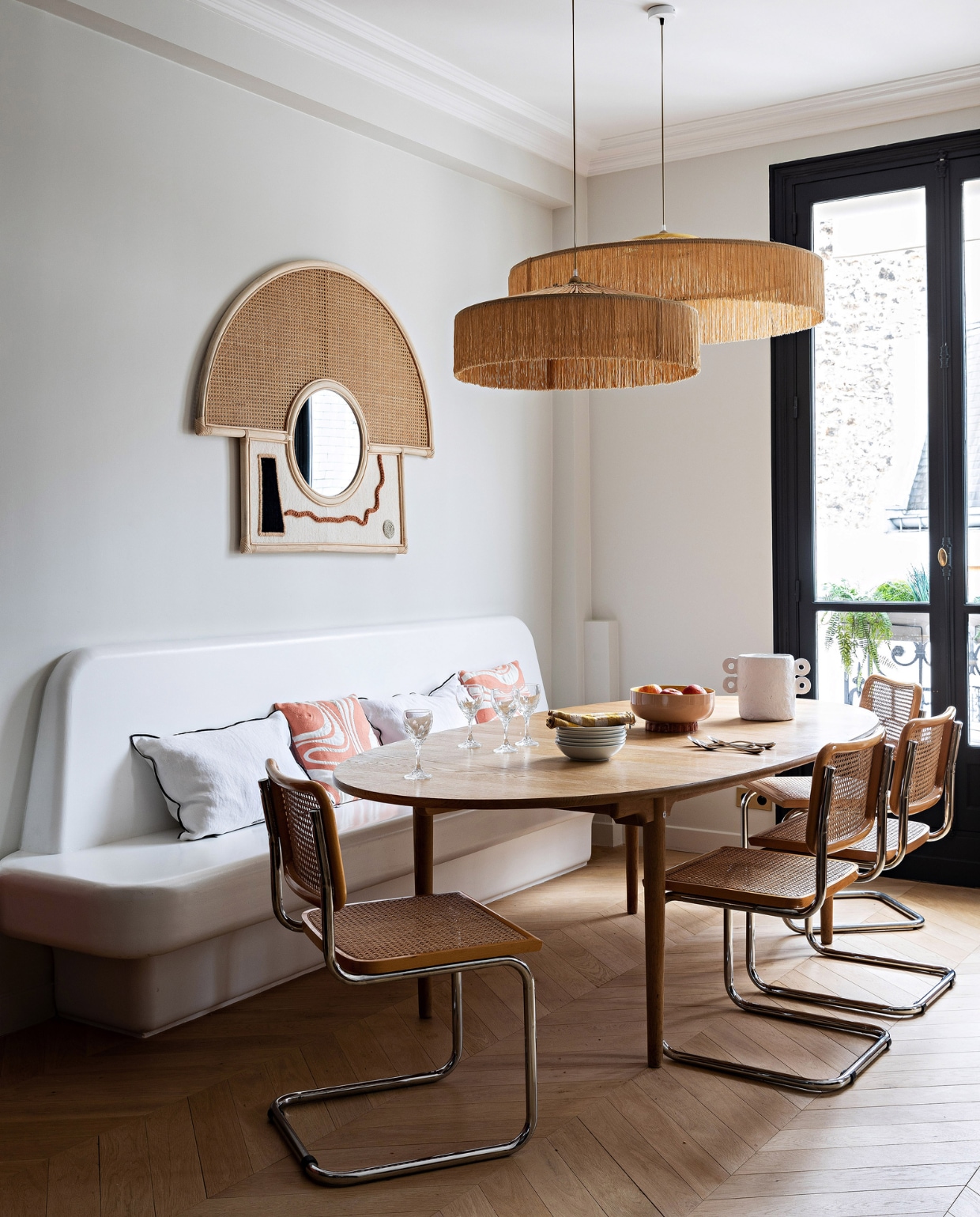 Tafel Intérieur Scandinave, stoelen van Marcel Breuer van vlooienmarkt Saint-Ouen. Bank zelfontworpen en gemaakt door Staff Décor, kussens India Mahdavi, hanglampen Honoré Déco, servies Monoprix, spiegel Lrnce Studio. Muurverf Strong White en verf kozijn Off Black van Farrow &amp; Ball. Vloer lag al in het huis. vtwonen 12-2023 | productie AC Scoffoni | styling Marie-Maud Levron | fotografie Yann Deret | tekstbewerking Merel van der Lande