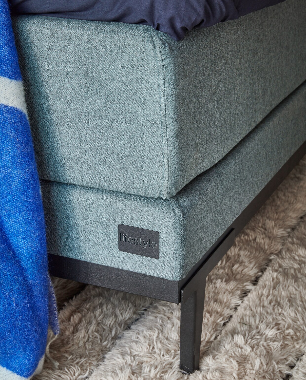 3&amp;4 Boxspring Lifestyle by vtwonen Pepper, vanaf € 1990,-, hier in stof Tweed Moss Green, met metalen poot Basic in antraciet.M.m.v. vtwonen.nl/shop (bijzettafel Twister van Polspotten, tafellamp van Hay), hm.com (dekbedovertrek), arket.com (plaid). Overig privébezit. vtwonen 13-2023 | productie Tanja Saarberg | styling Sanne Ketelaar | fotografie Peggy Janssen