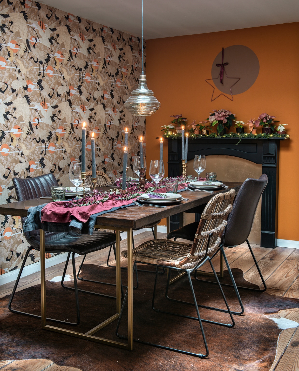 Behang Mind the Gap. Eettafel Dutchbone, rieten stoelen Leen Bakker, leren stoelen gevonden in een outlet. Hanglamp Be Pure Home, koeienhuid koelap.nl. Gebloemde borden en kandelaars van de kringloop, andere borden Kwantum, kaarsen en waterglazen Xenos, wijnglazen gekregen. Kerststerren en decoratie Intratuin. Tafellopers zelf genaaid. vtwonen 12-2020 | Styling Mindy Schroor | Fotografie Ton Bouwer | Productie Monique van der Pauw