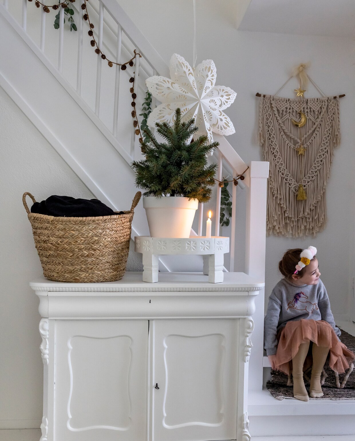 Vlinder zit op de trap in de huurwoning van moeder Johanna. Kast Marktplaats. Mand Kwantum. Marokkaans tafeltje Xenos zelf wit geverfd. Vloerkleed uit Marokko Vinted. Pot van tuincentrum zelf wit geverfd. Kerstster Søstrene Grene. Dennen-appelslinger Casashops, gouden hanger Su-ah. Zwart-wit kleedje Loftloft. Wandkleed macramé zelf-gemaakt. Overig onbekend. vtwonen 13-2023 | fotografie Henny van Belkom | tekst Ina Babbé