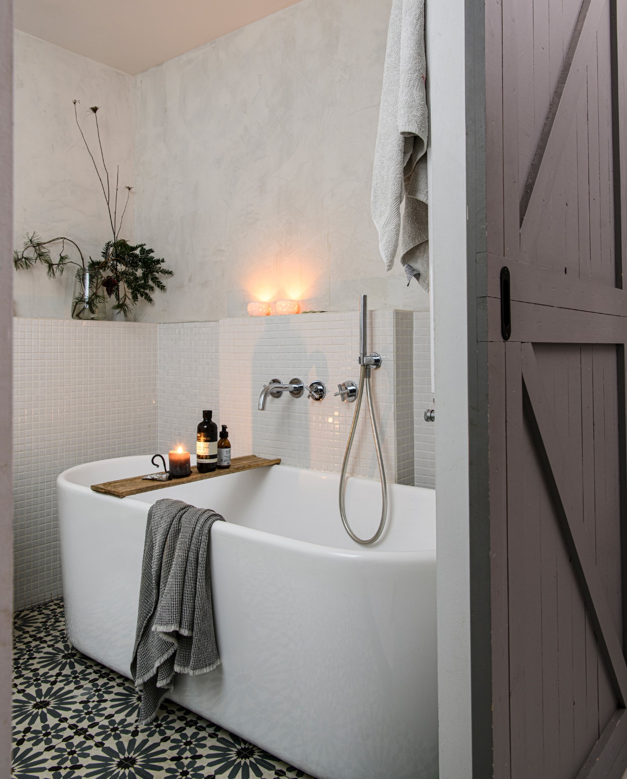 Muurverf Marrakech Walls Ashes van Pure & Original, wandtegels Ton Scholten, vloertegels Designtegels. Vazen en kandelaars kringloop. Bad Sanidirect, kranen Ben Sanitair, houten plank Xenos. Zeeppomp en badschuim Dille & Kamille. Kaars Casa, handdoeken H&M Home. vtwonen 13-2023 | productie Insidehomepage | fotografie Louis Lemaire