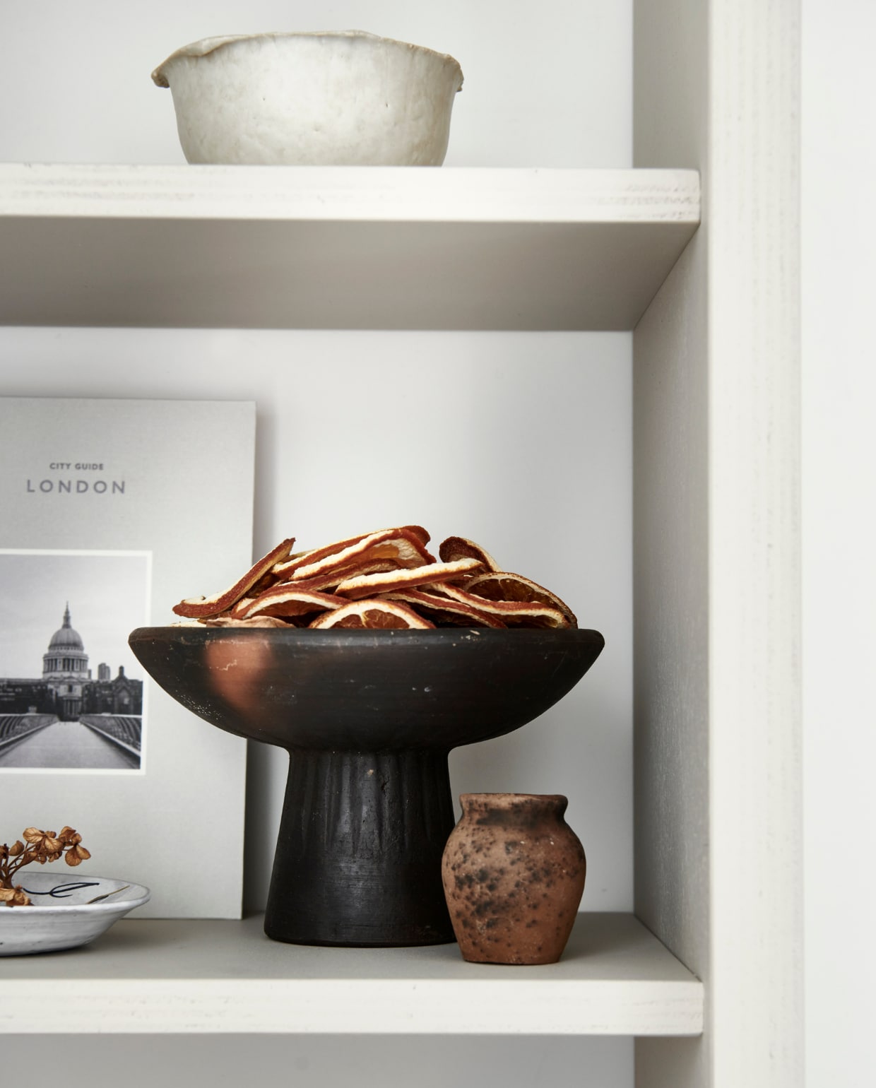 Verf op de kast Rolling Fog 143 (littlegreene.nl). Boek Cereal City Guide London € 24,- (zarahome.com) schaal op poot Mura Bowl € 24,95 (casagitane.com). Droogbloemen prijs op aanvraag (edenique.nl). Overig privébezit. vtwonen 12-2021 | productie &amp; styling Kim van Rossenberg | uitvoering Richard van Meerveld | fotografie Sjoerd Eickmans