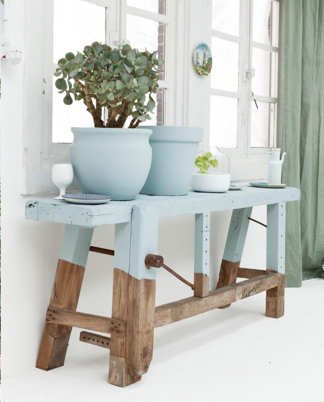 Oude werkbank (Vroeger &amp; Toen) deels geschilderd in kleur Celestial Blue van The Little Greene (De Ru). Grote terracotta potten (Tuincentrum Osdorp). Bak met glazen stolp(Store without a home). Koffiepot, wit keramisch wijnglas (Pols Potten). Gordijn Epoca Kleve groen van Jaap Bos 100% linnen 300 cm hoog (Dotshop). Dienblad (Store without a home). Bordjes (Waterlooplein, Amsterdam). vtwonen 05-2013 | styling Frans Uyterlinde | fotografie Jansje Klazinga