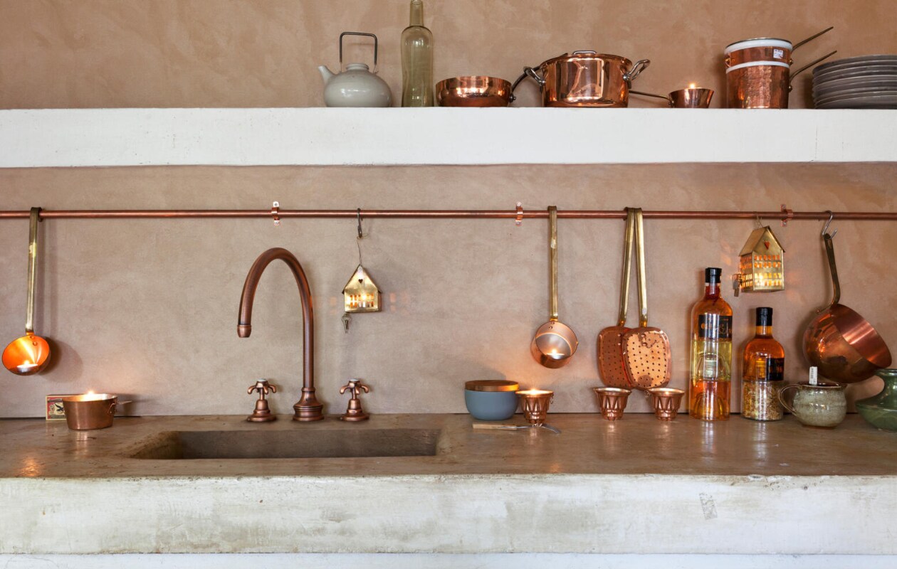 Bovenste plank: theepot van Ptze Porselein Atelier, fles (Meker Wonen). Sauspan nr 550, kookpan 436, steelpan, au-bain-marie-pan (Duikelman). Sixties dessertbordjes (Nijhof). Onderste plank: koperen buis (www.metaalwinkel.nl). Soeplepels, steelpan, bakvormpjes nr 8221, schuimspanen (Duikelman). Koperen huisjes (Maison NL). Bakje met deksel, flessen slaolie, keramisch potje met lepel (Nijhof). Sabayon-pan nr 728 (Duikelman). Volevatch 3-gaats keukenkraan met kruishendels in oud koper met een satin finish (Baden Baden Interior). Wandbewerking Dorado Paste van Earthcote (Louers). vtwonen 12-2013 | styling Frans Uyterlinde | fotografie Jansje Klazinga