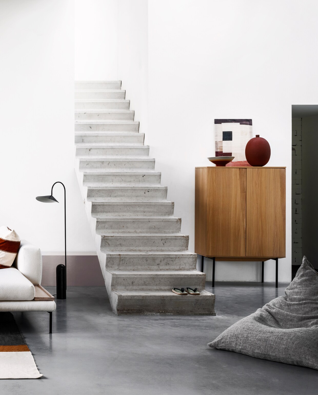 zwarte vloerlamp Arum met stenen voet van Ferm Living (kolkenkolk.nl). Bank met chaise longue van Bolia, 310x185 cm (bxd), kast van geolied eiken met stalen poten van Bolia, 155x100x45 cm (hxbxd), schaal, vaas (boer-staphorst.nl). Kommen van HKliving, ronde metalen bijzettafel Place van Ferm Living (vtwonen.nl). Vloerkleed Nash van grote wollen deken, 260x240 cm (libeco.com). Zitzak van linnen stof met Japans dessin, 135x90 cm (maomi.de). vtwonen 05-2020 | styling Marianne Luning | fotografie Stan Koolen