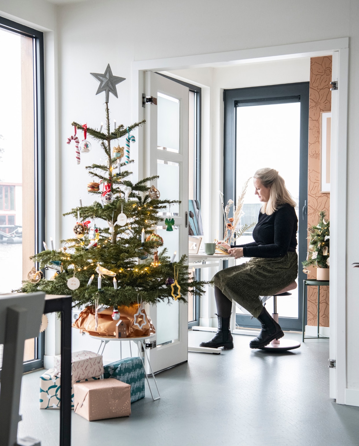 Kerstboom op standaard Kerstboombox. Kruk LavaBird. Behang Roomblush. Bijzettafel Ikea.Bureau herkomst onbekend. vtwonen 12-2023 | productie Insidehomepage | styling Laura Gommans | fotografie Louis Lemaire